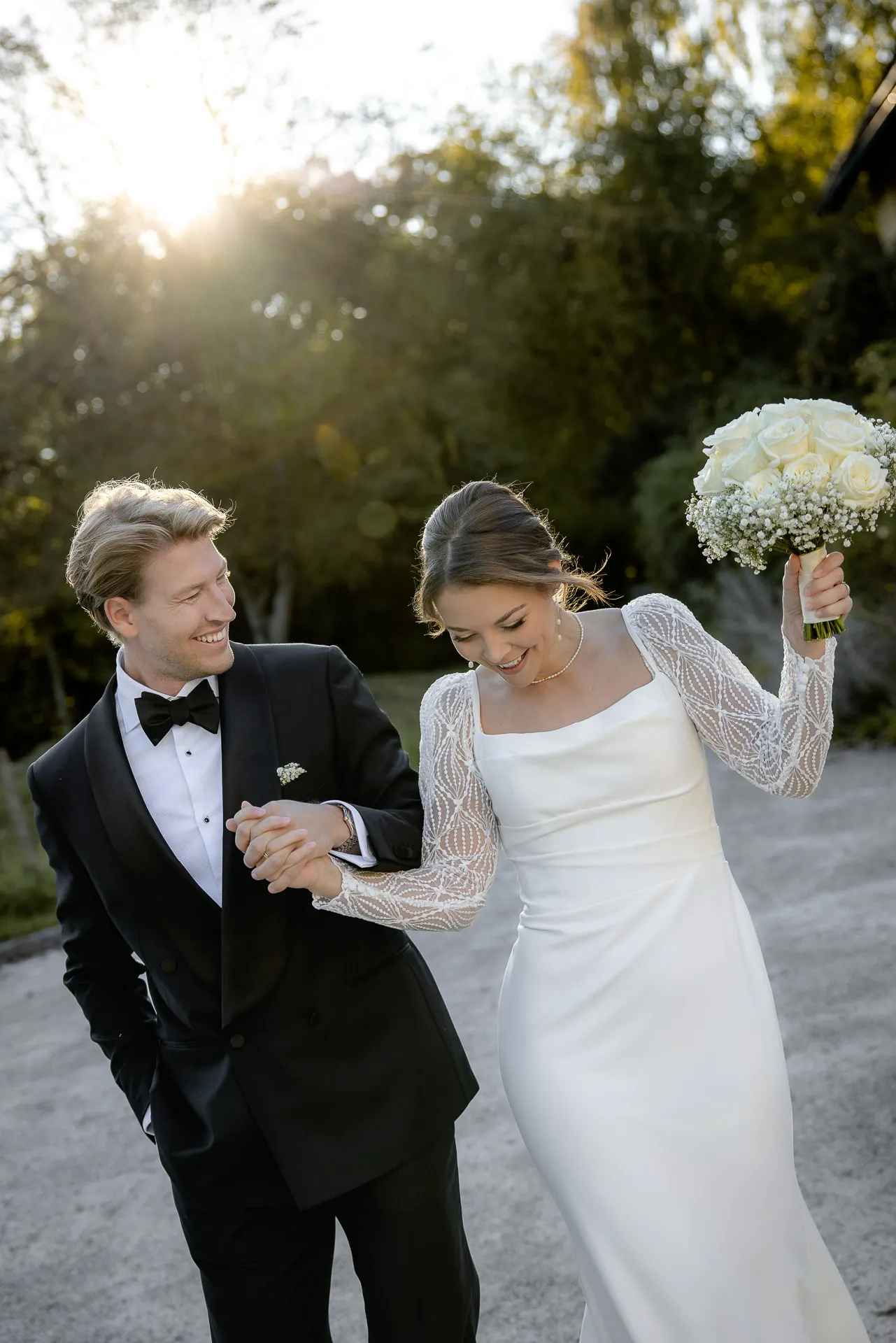 Wedding couple walks hand in hand with bridal bouquet at Gut Sonnenhausen estate