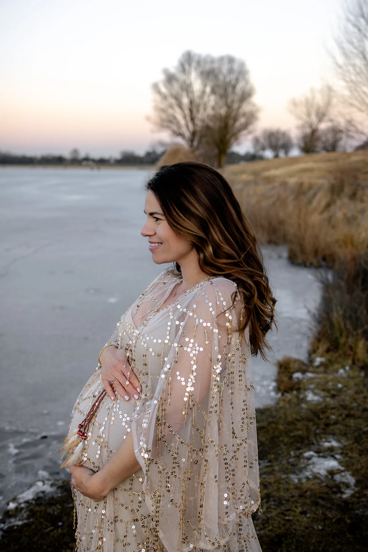 Outdoor-Babybauchporträt im Winter am See München