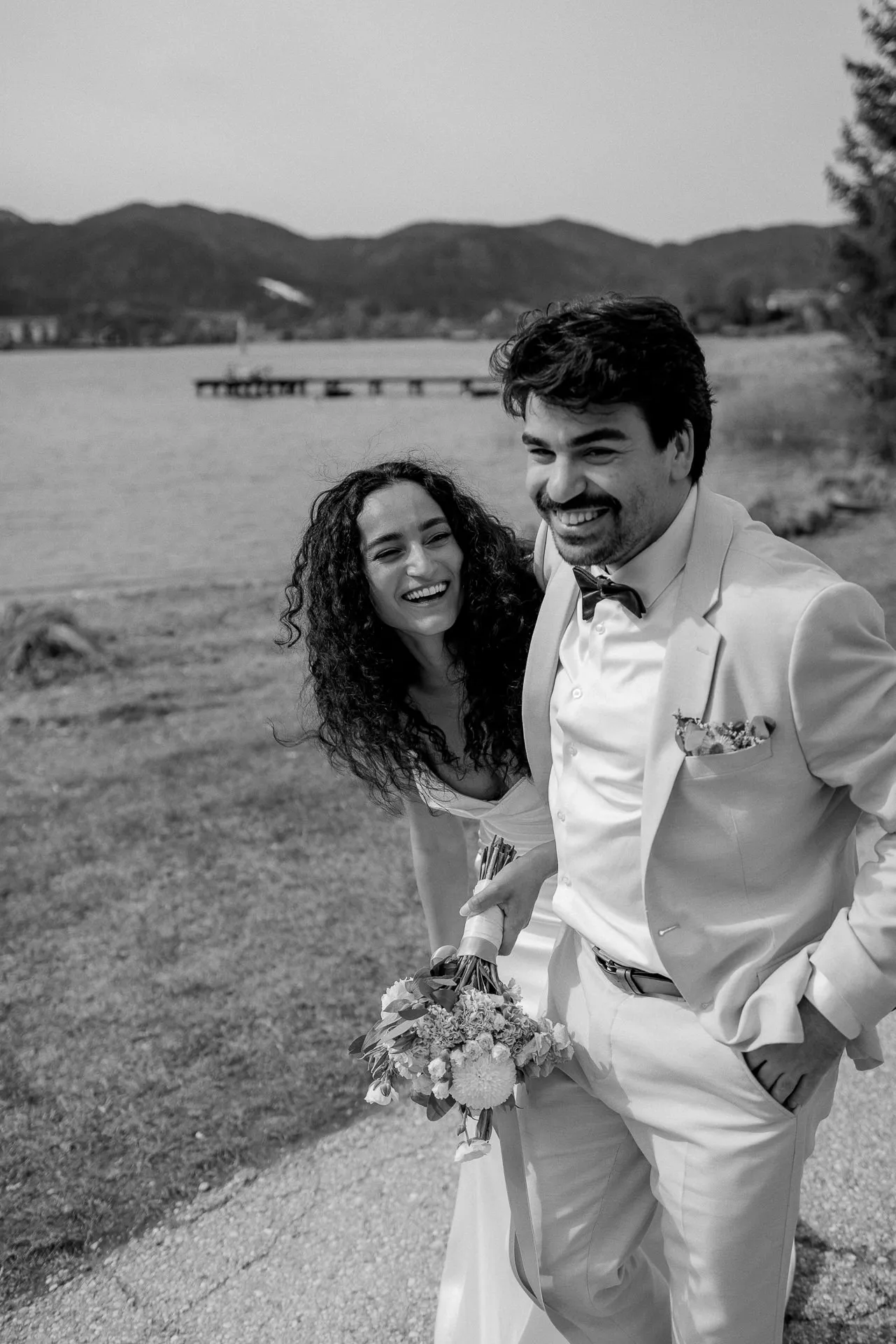 Wedding couple Eren and Damla laughing at Lake Tegernsee after civil ceremony