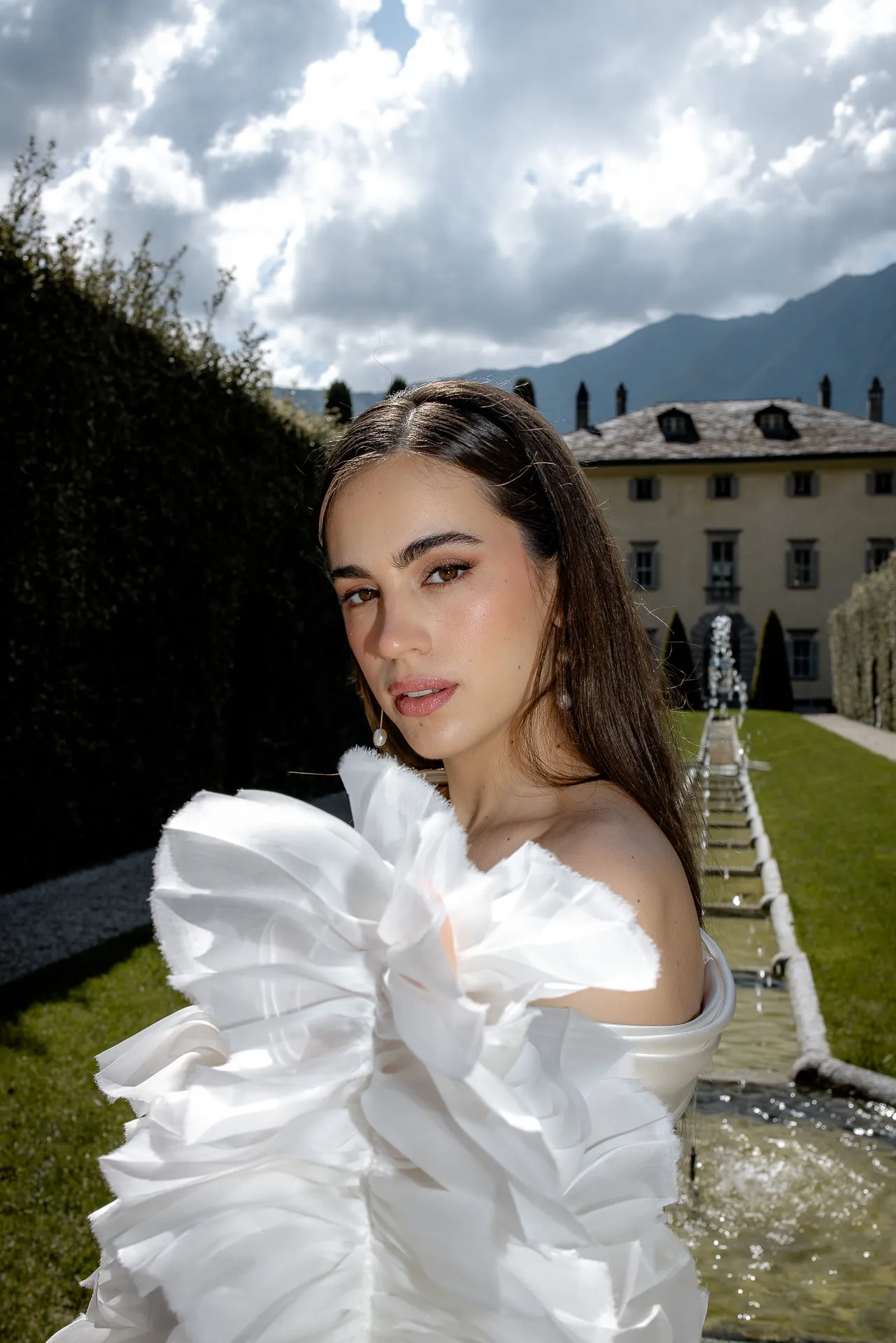Bride in couture wedding dress with ruffles in Villa Balbiano Lake Como garden