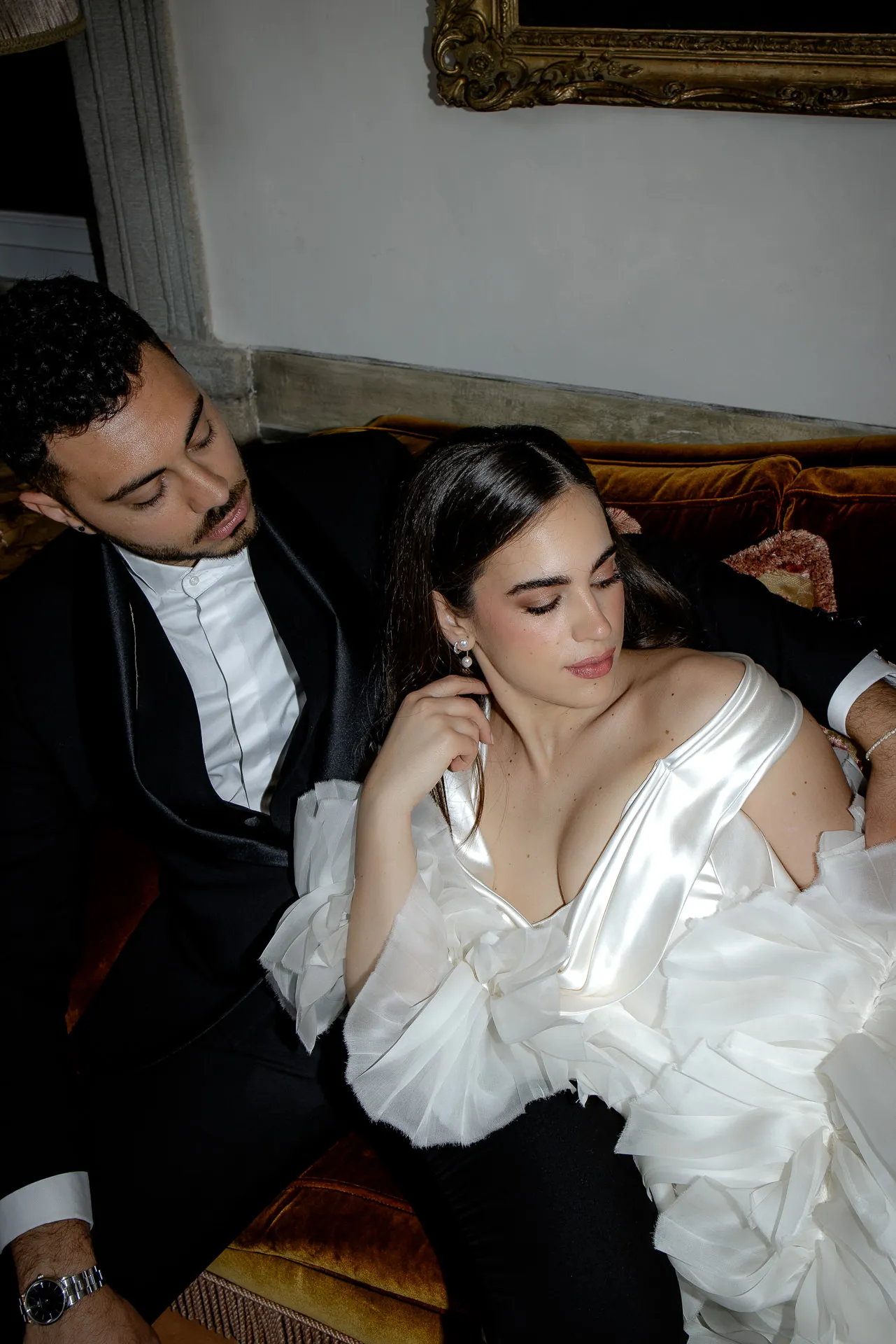 Intimate wedding couple moment on antique sofa in Villa Balbiano