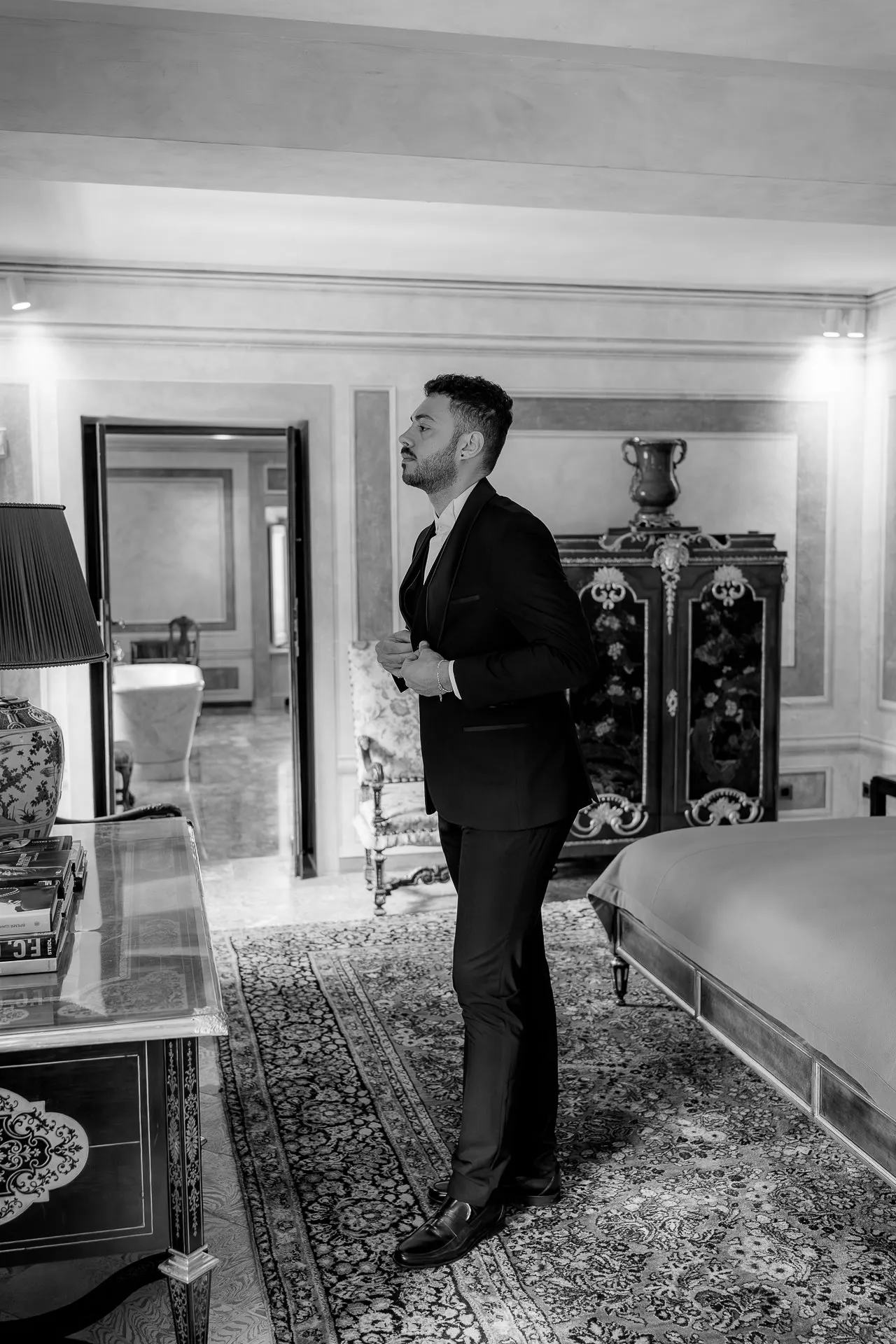 Groom portrait in elegant suit in antique salon of Villa Balbiano