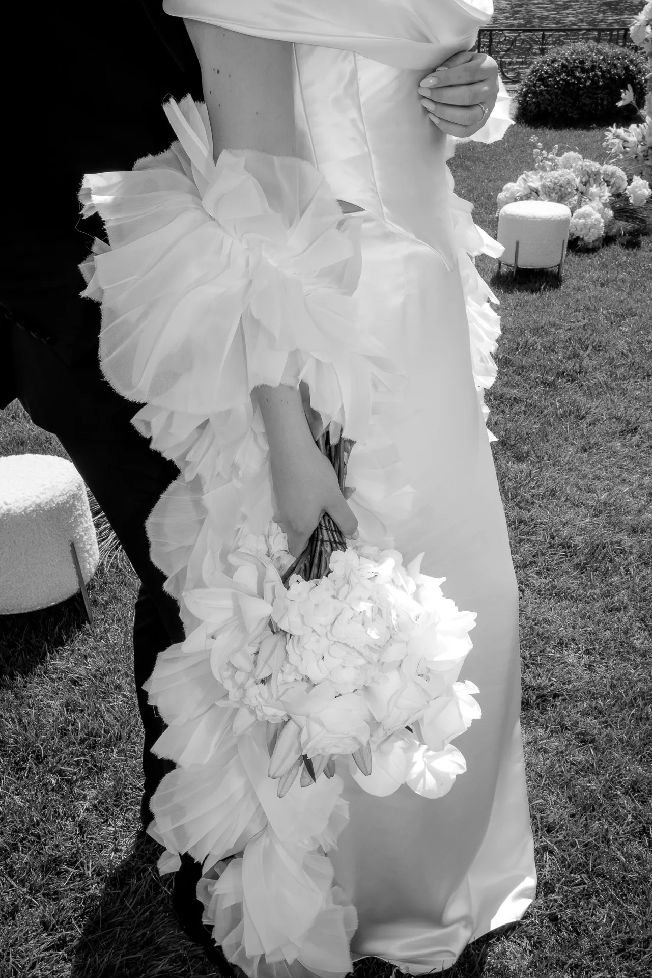 Artistic black and white detail of bride with bouquet at ceremony