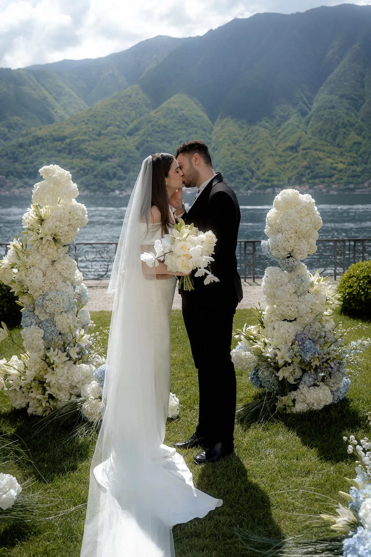 Wedding couple kissing at Villa Balbiano Lake Como ceremony with mountain view