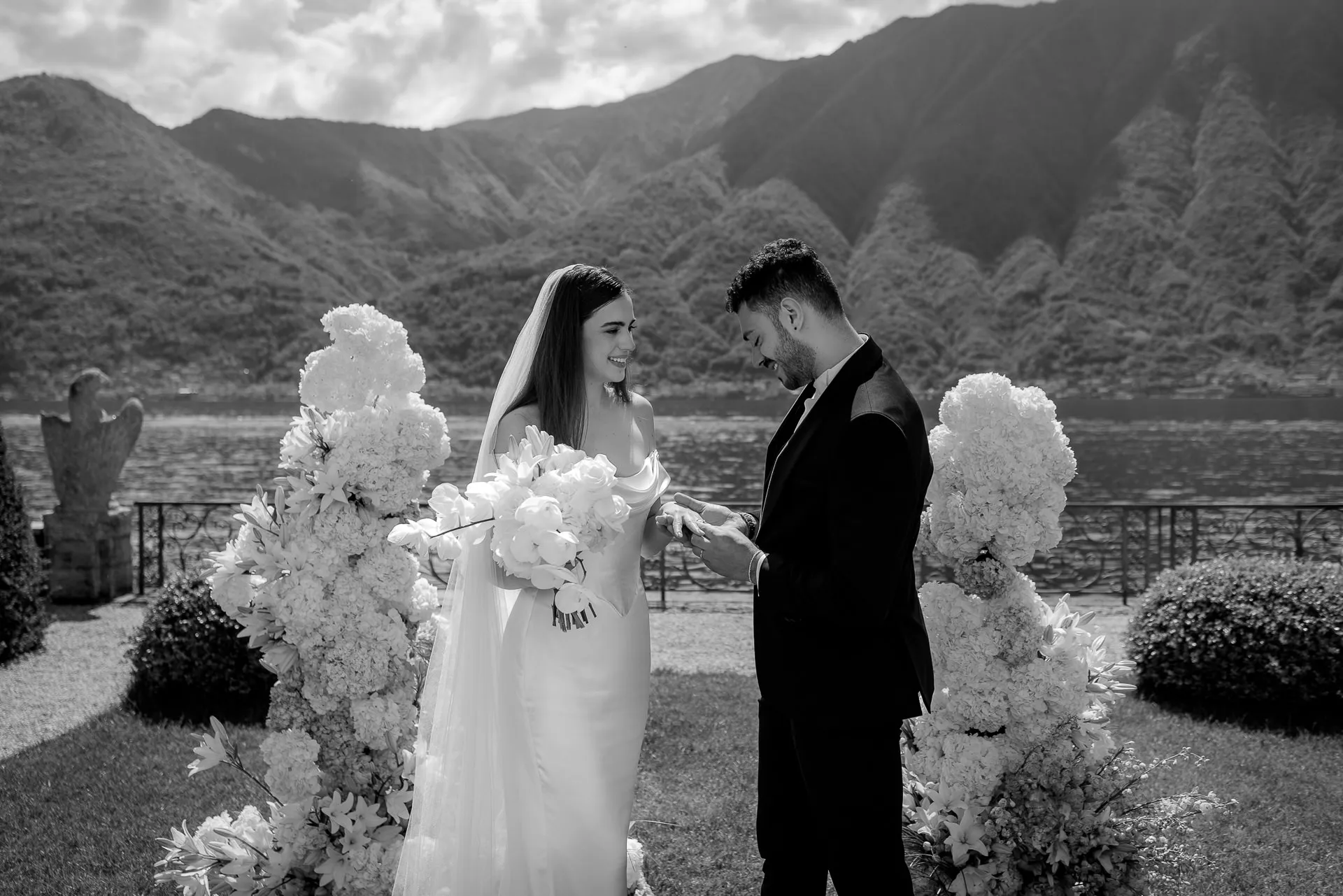 Ring exchange at Lake Como wedding ceremony with white floral decoration black and white