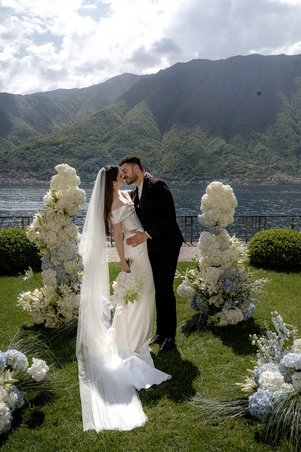 Romantic kiss at Villa Balbiano wedding ceremony with lake view and mountains