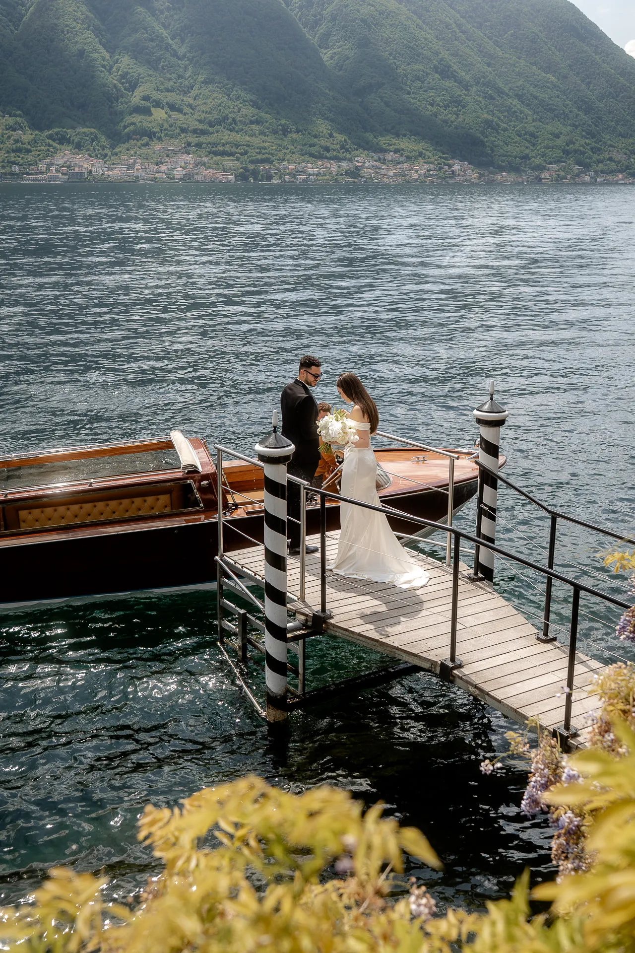 Wedding couple on private boat dock at Lake Como with luxury motorboat