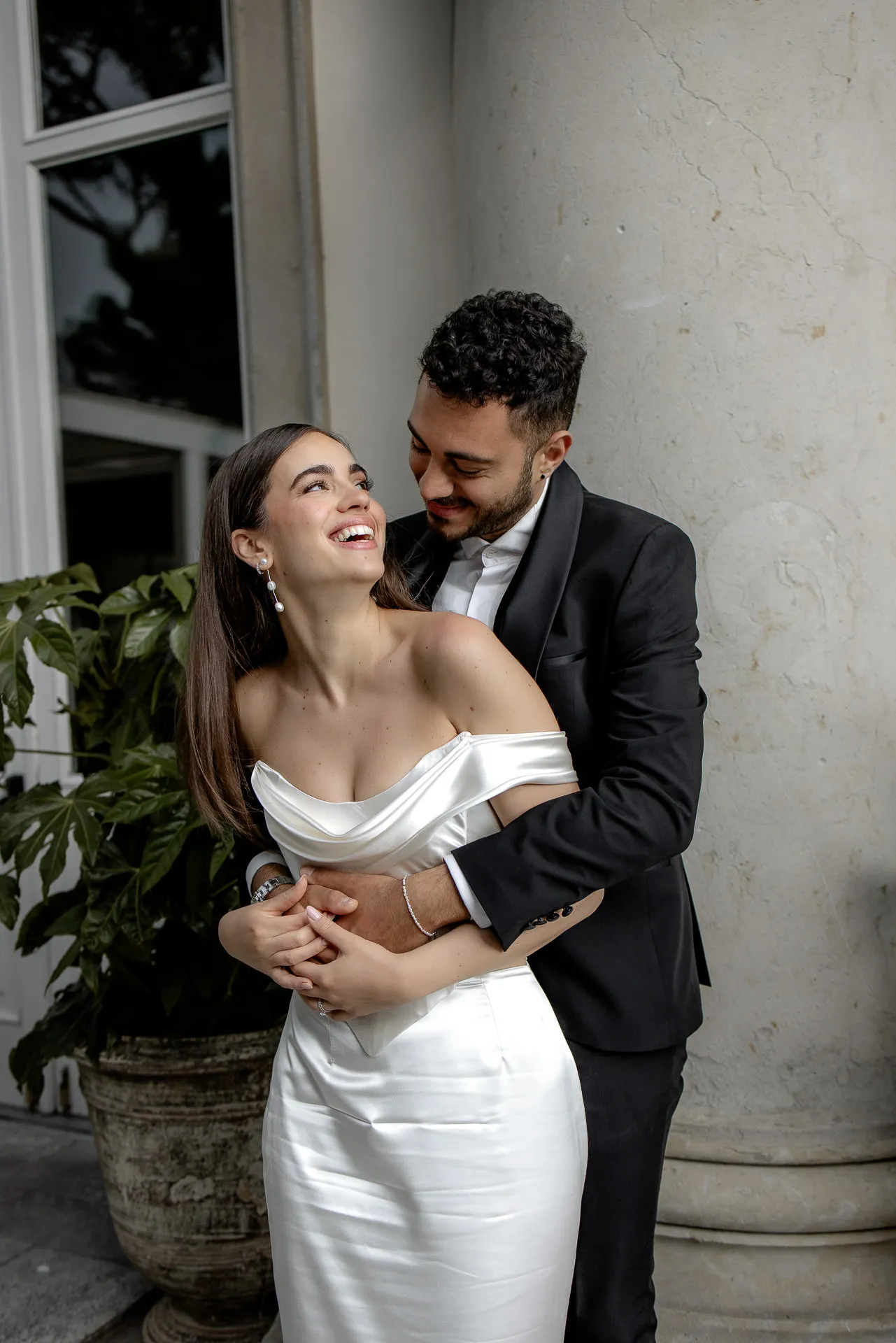 Happy wedding couple embracing before historic column at Villa Balbiano