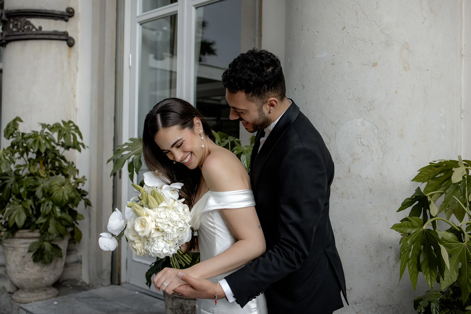 Laughing wedding couple with bridal bouquet before Villa Balbiano