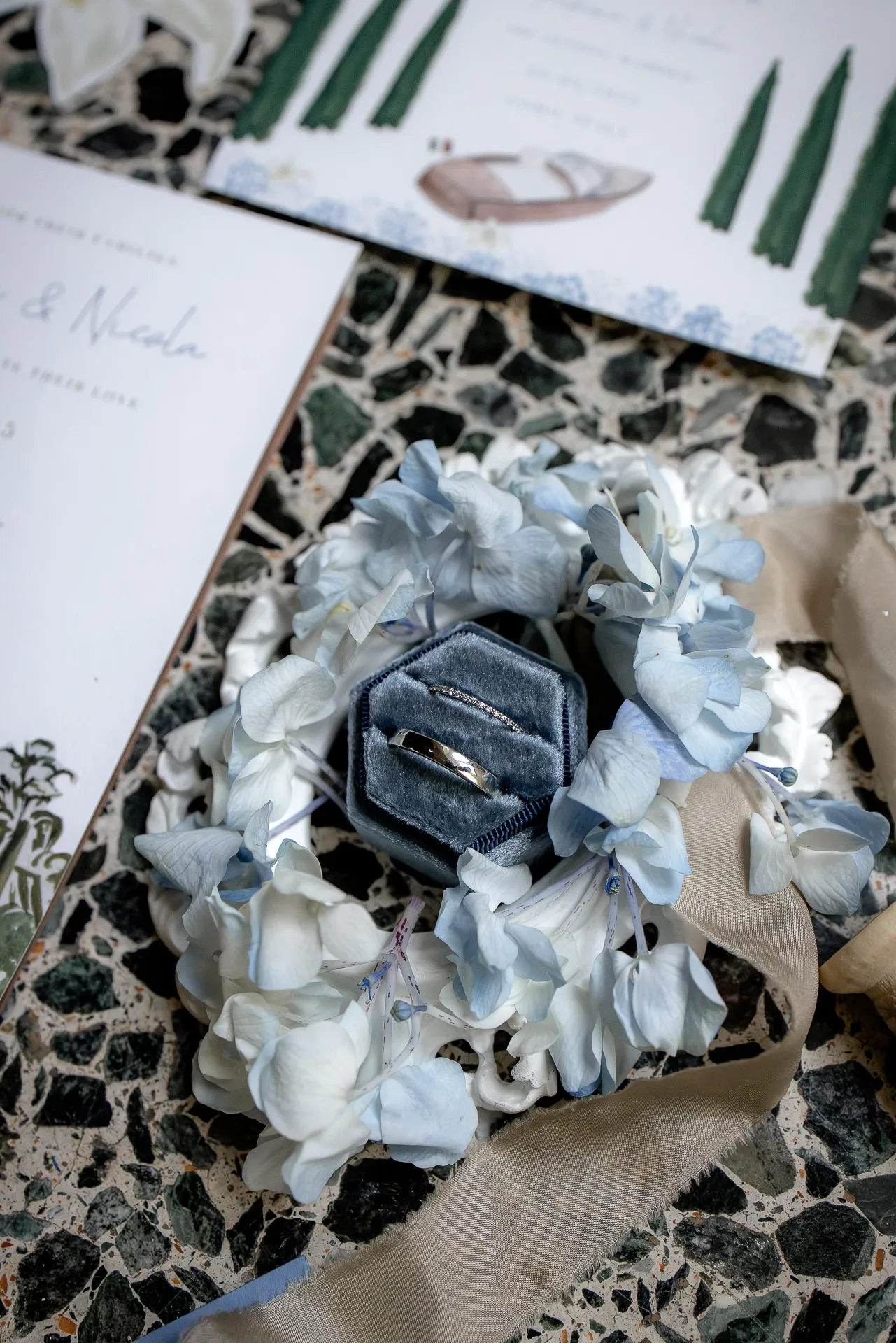 Detail shot of wedding rings in blue ring box with hydrangeas Villa Balbiano