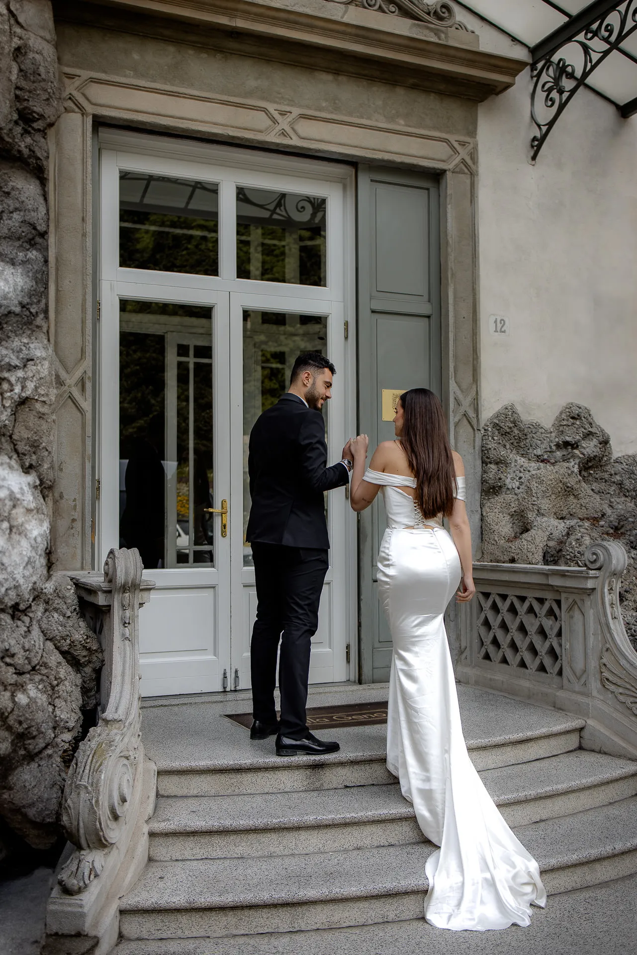 Wedding couple entering historic Villa Balbiano through antique entrance
