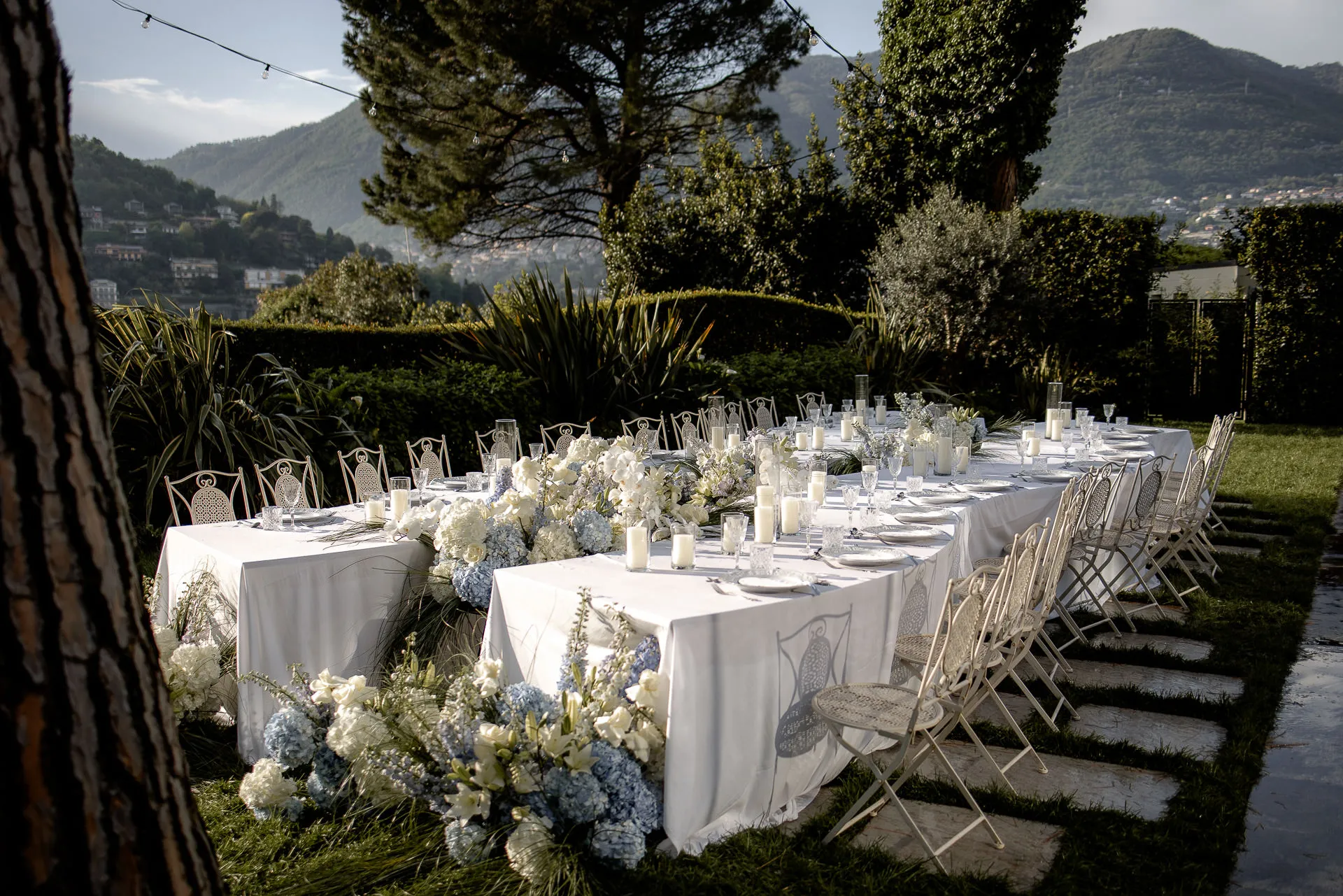 Luxurious outdoor wedding table at Villa Balbiano with white floral decoration and mountain view