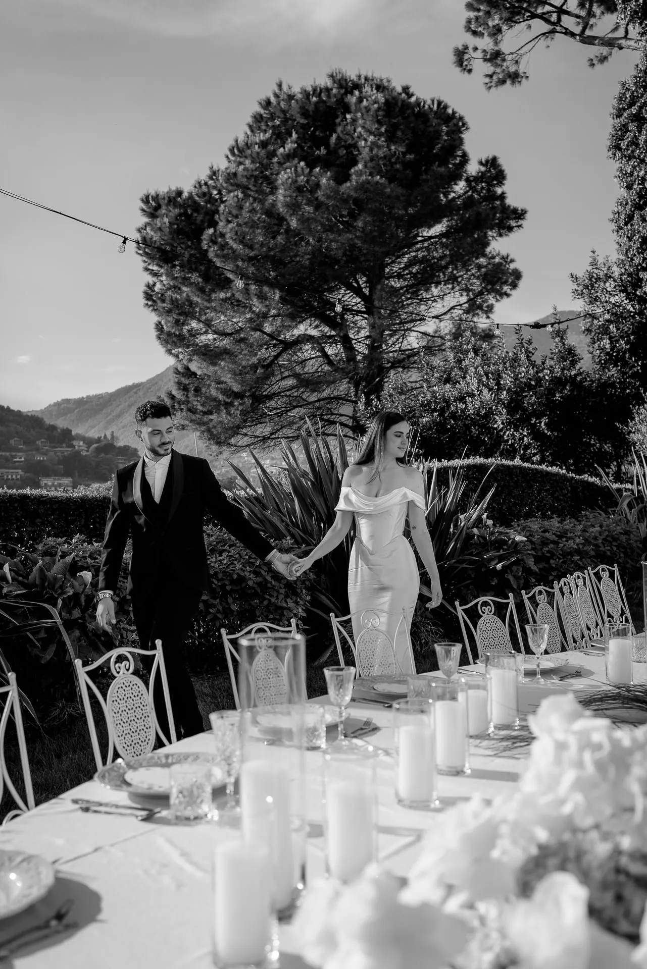 Wedding couple walking along festively set table at Lake Como black and white