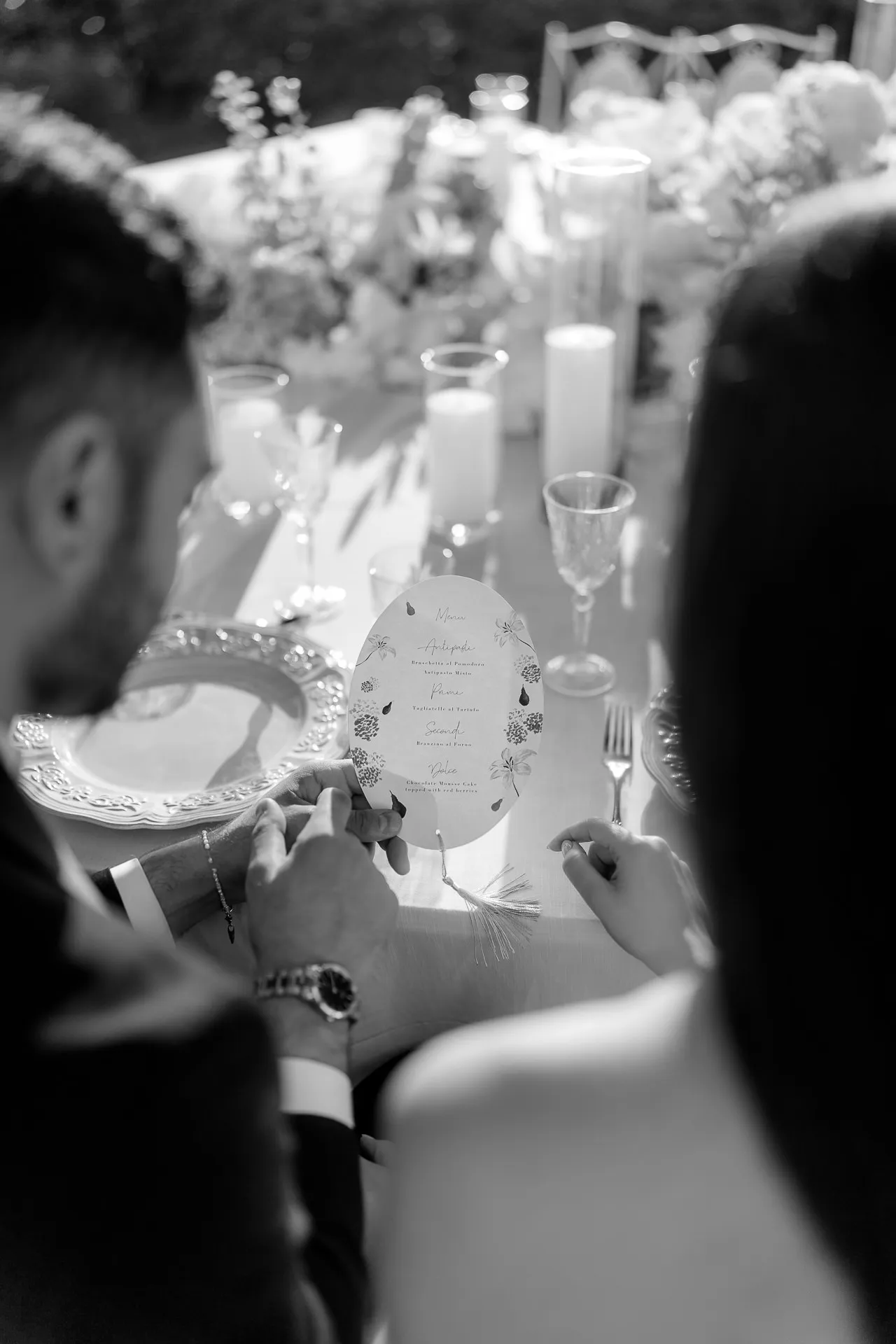 Guest reading menu card at elegant Villa Balbiano wedding black and white