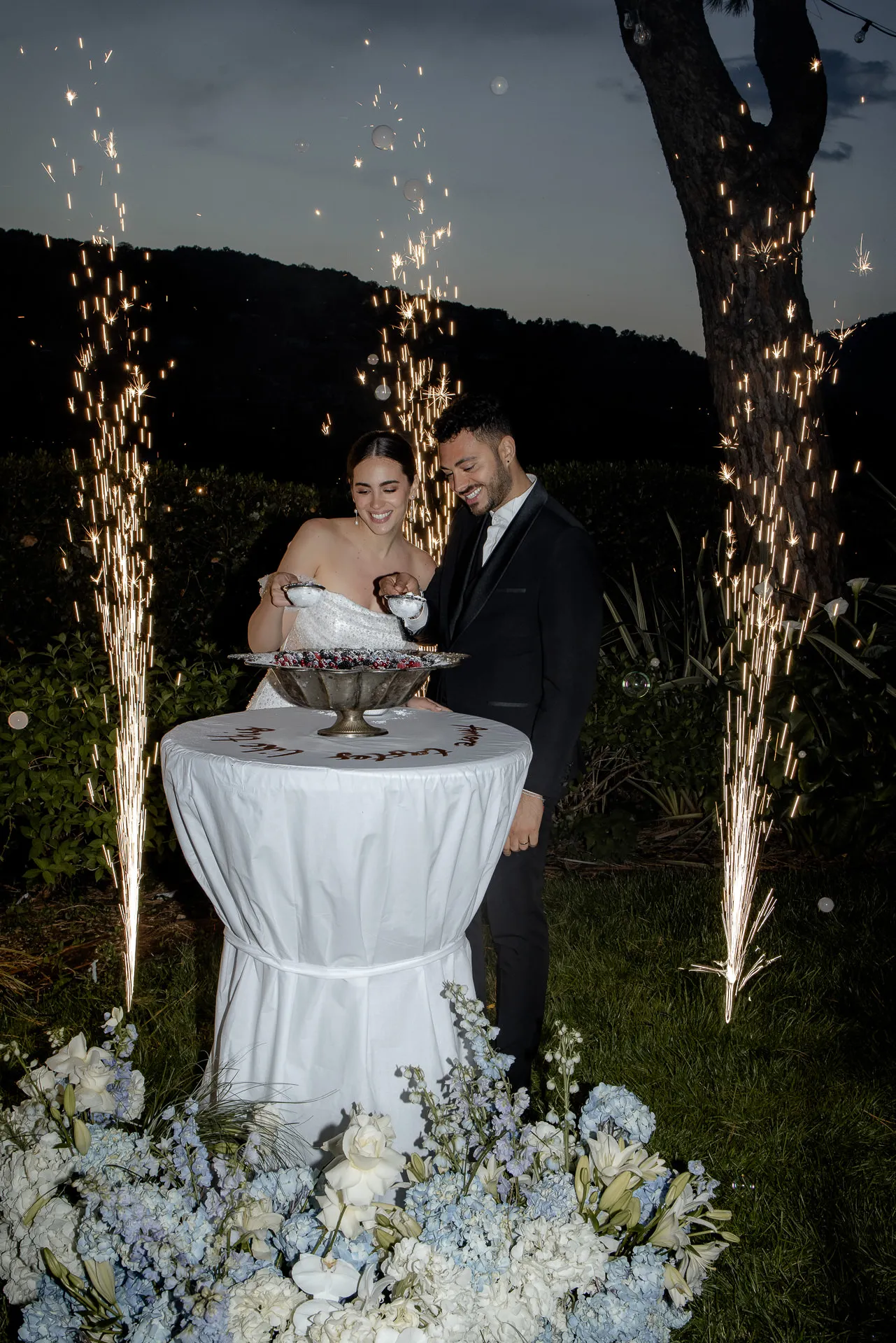 Wedding couple at cake cutting with golden sparkler fountains at Villa Balbiano