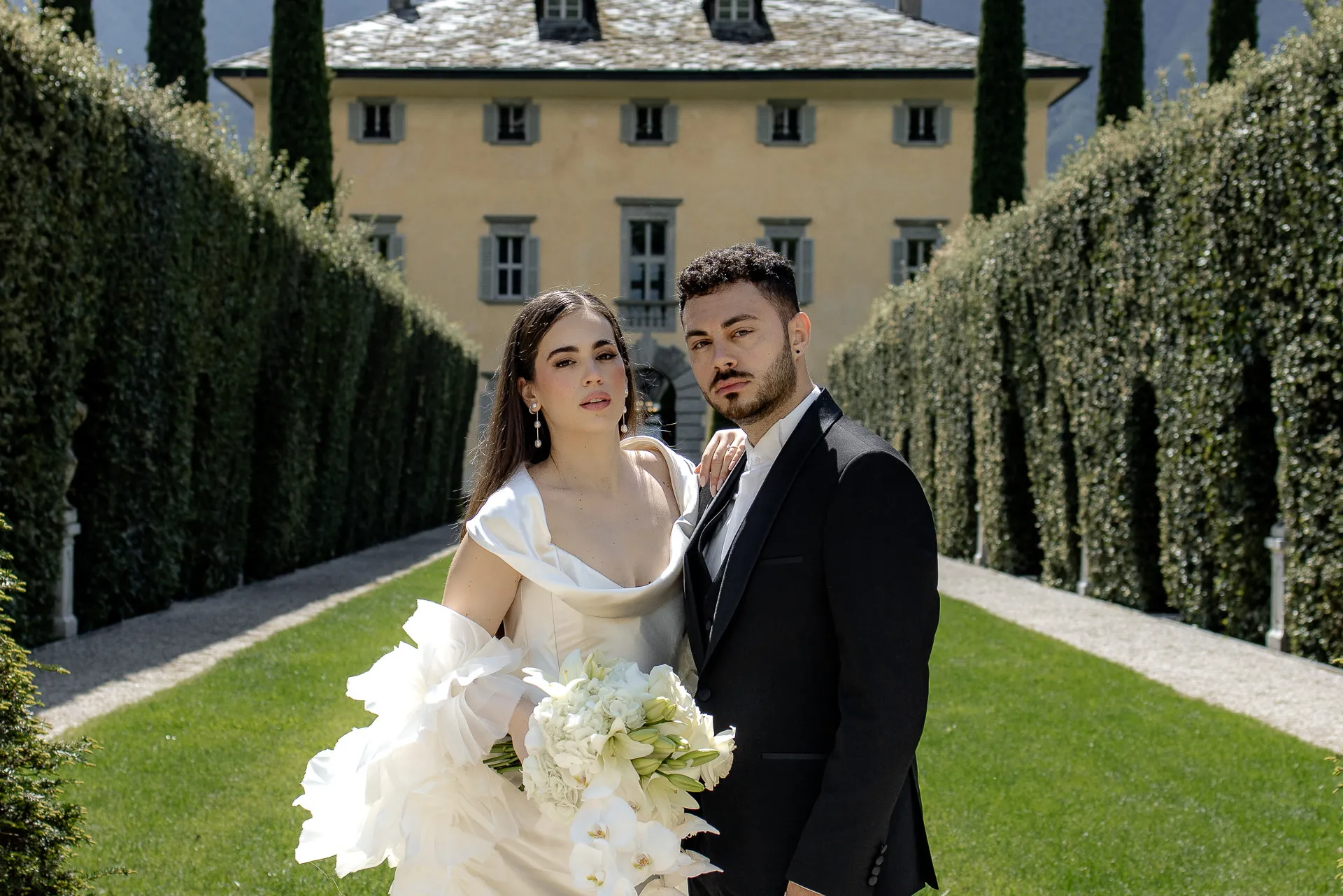 Wedding couple before Villa Balbiano with dramatic mountain backdrop at Lake Como