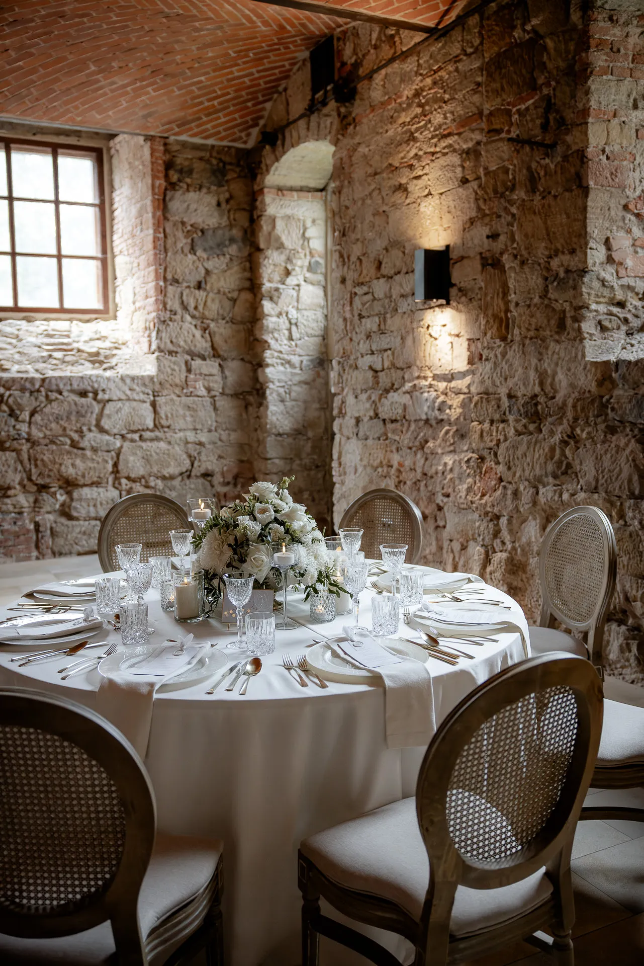 Romantic wedding table with white flower decoration in rustic vault at Schloss Eyrichshof