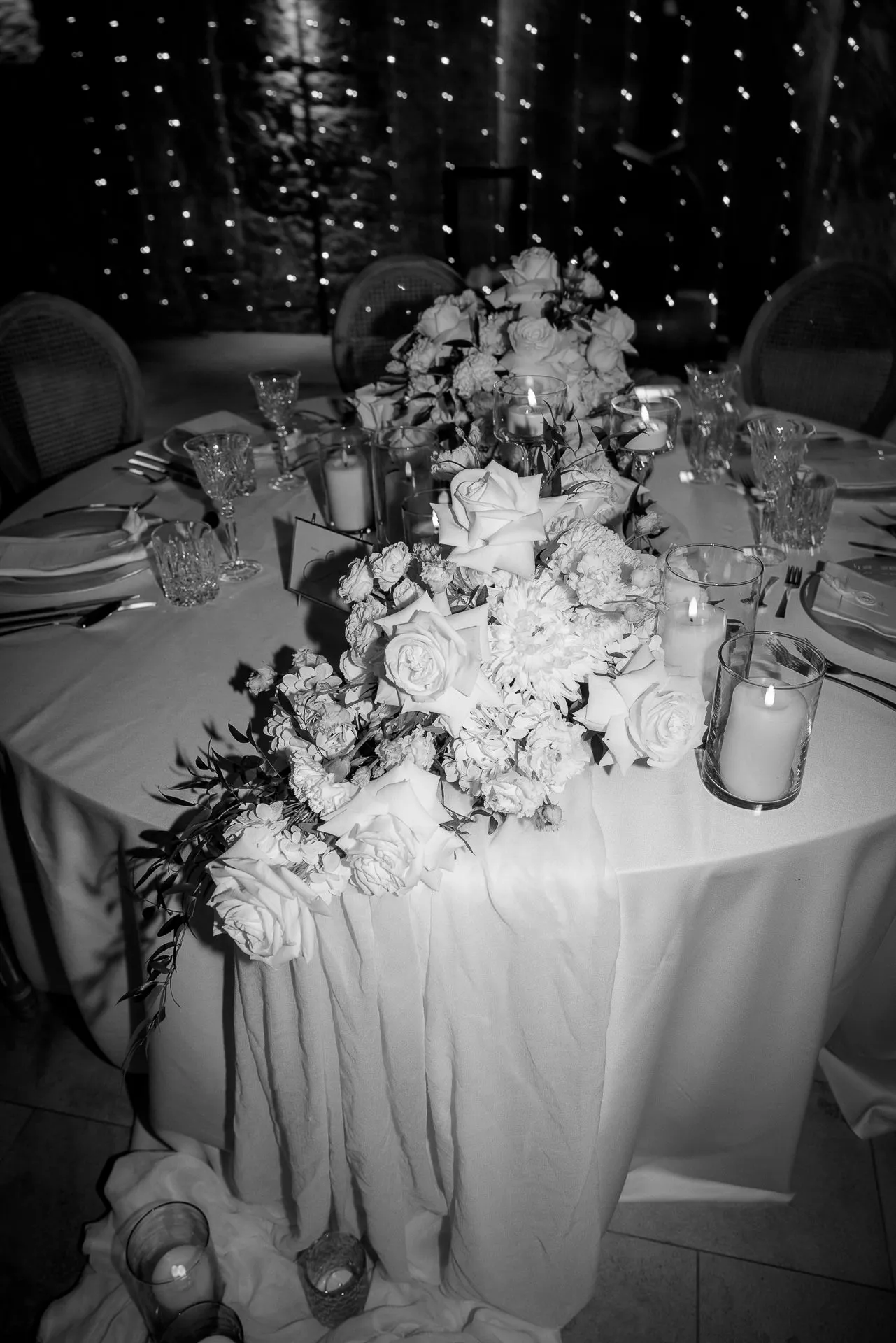 Elegant bride's table with romantic flower runner and candles in black and white