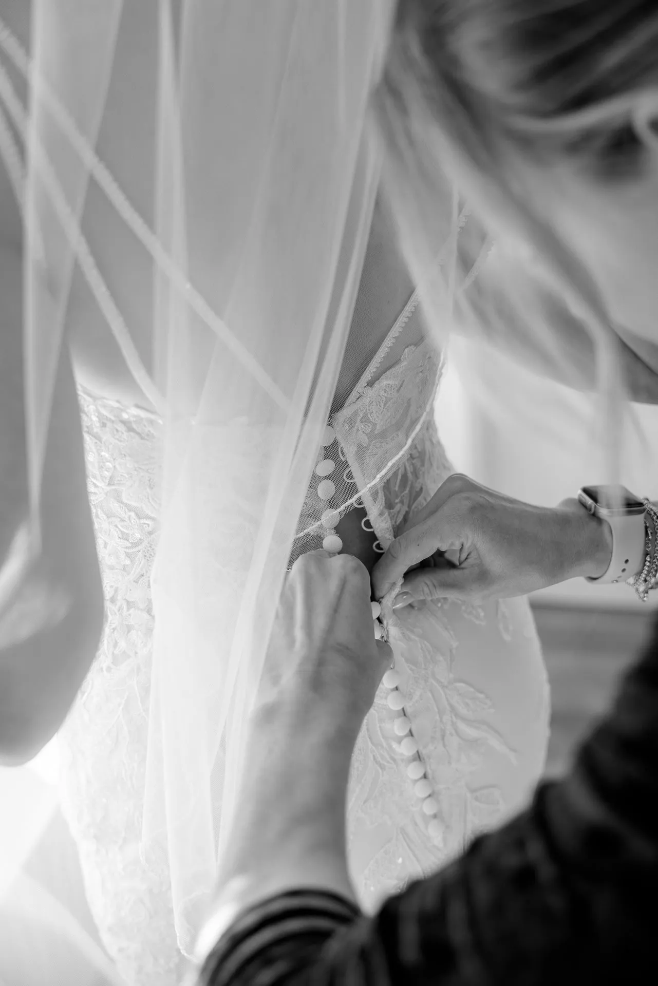 Wedding dress with lace details being laced up in black and white wedding photography