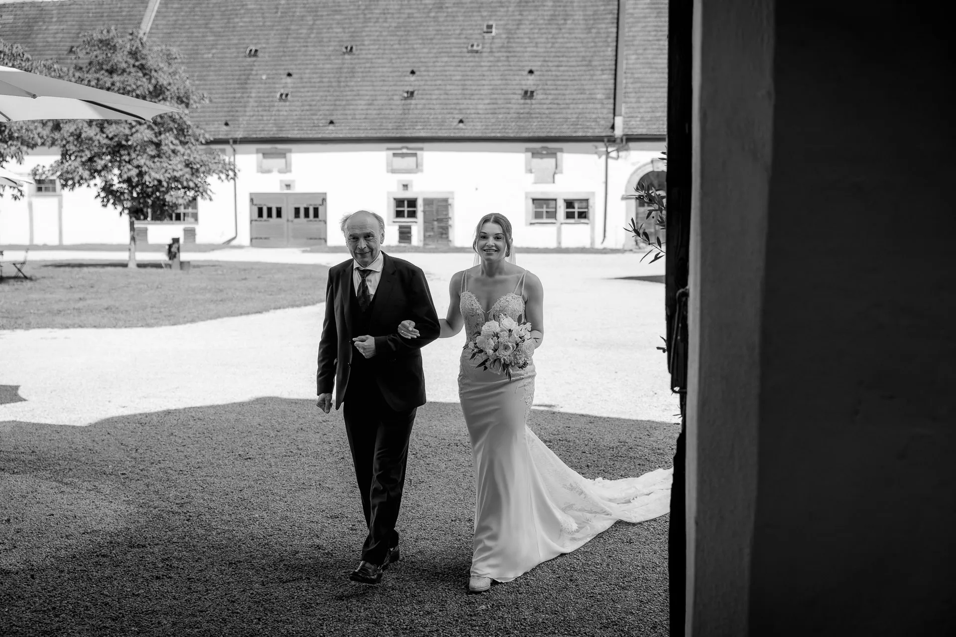 Bride with father entering wedding ceremony at Schloss Eyrichshof in black and white