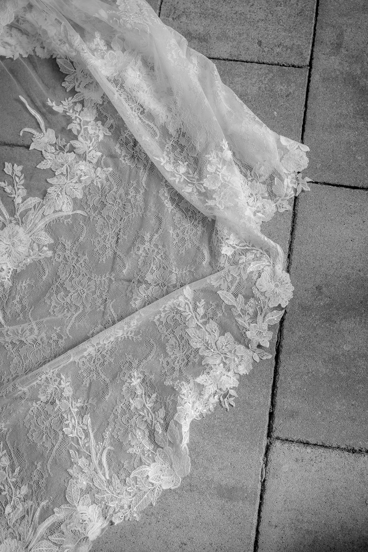 Detail shot of wedding dress with lace and veil in black and white wedding photography
