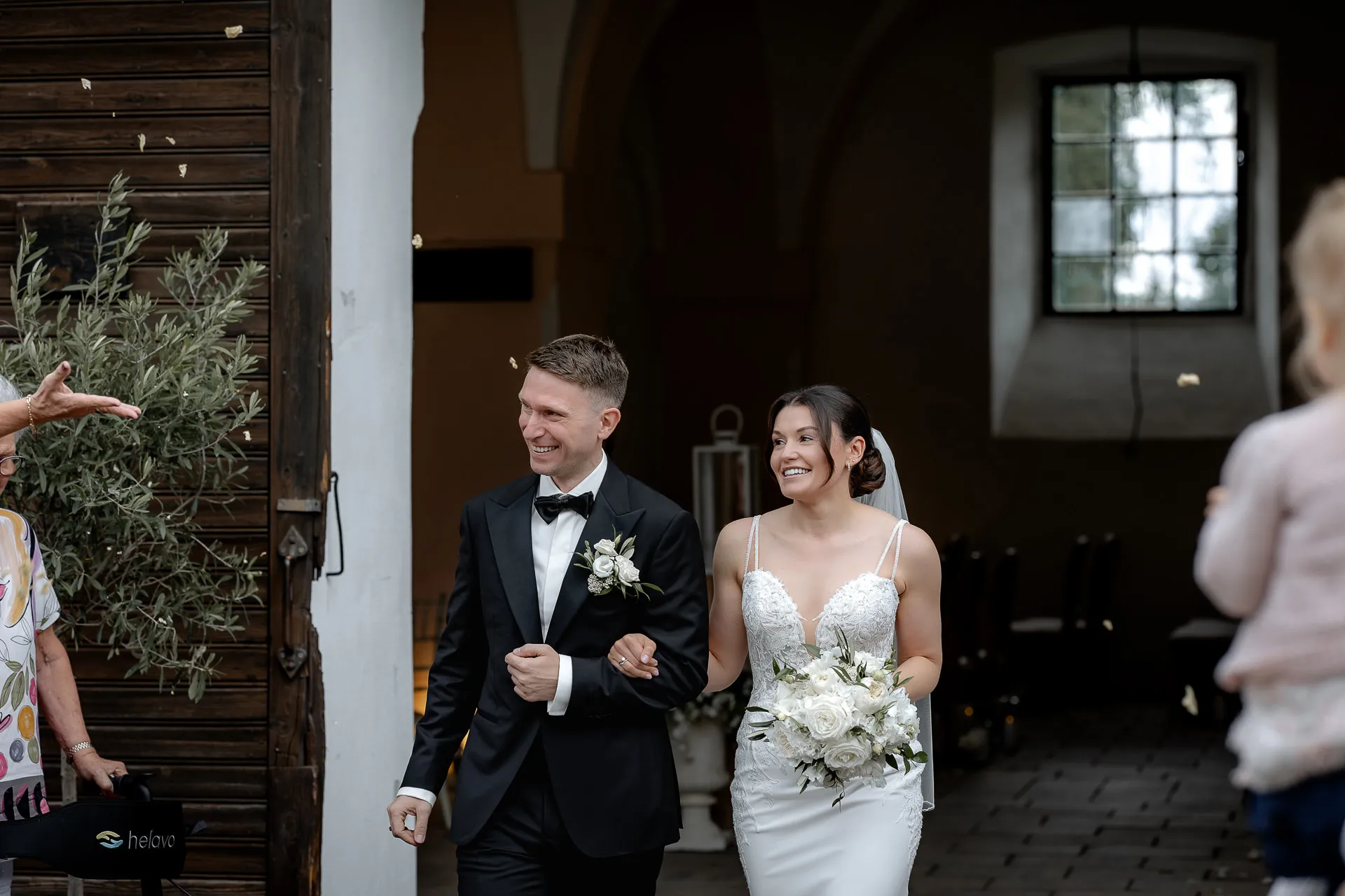 Happy newlyweds after ceremony exiting at Schloss Eyrichshof with wedding guests