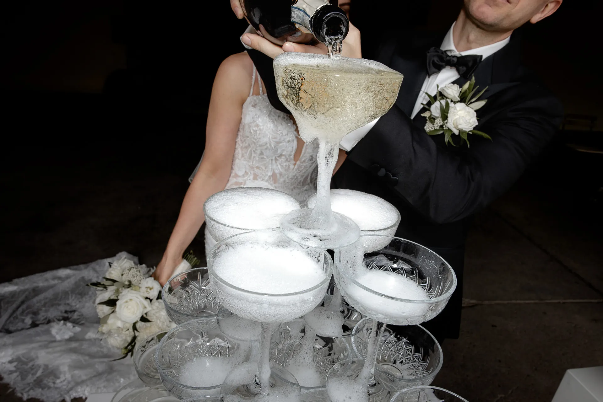 Bride and groom pouring champagne into champagne tower at wedding celebration Schloss Eyrichshof