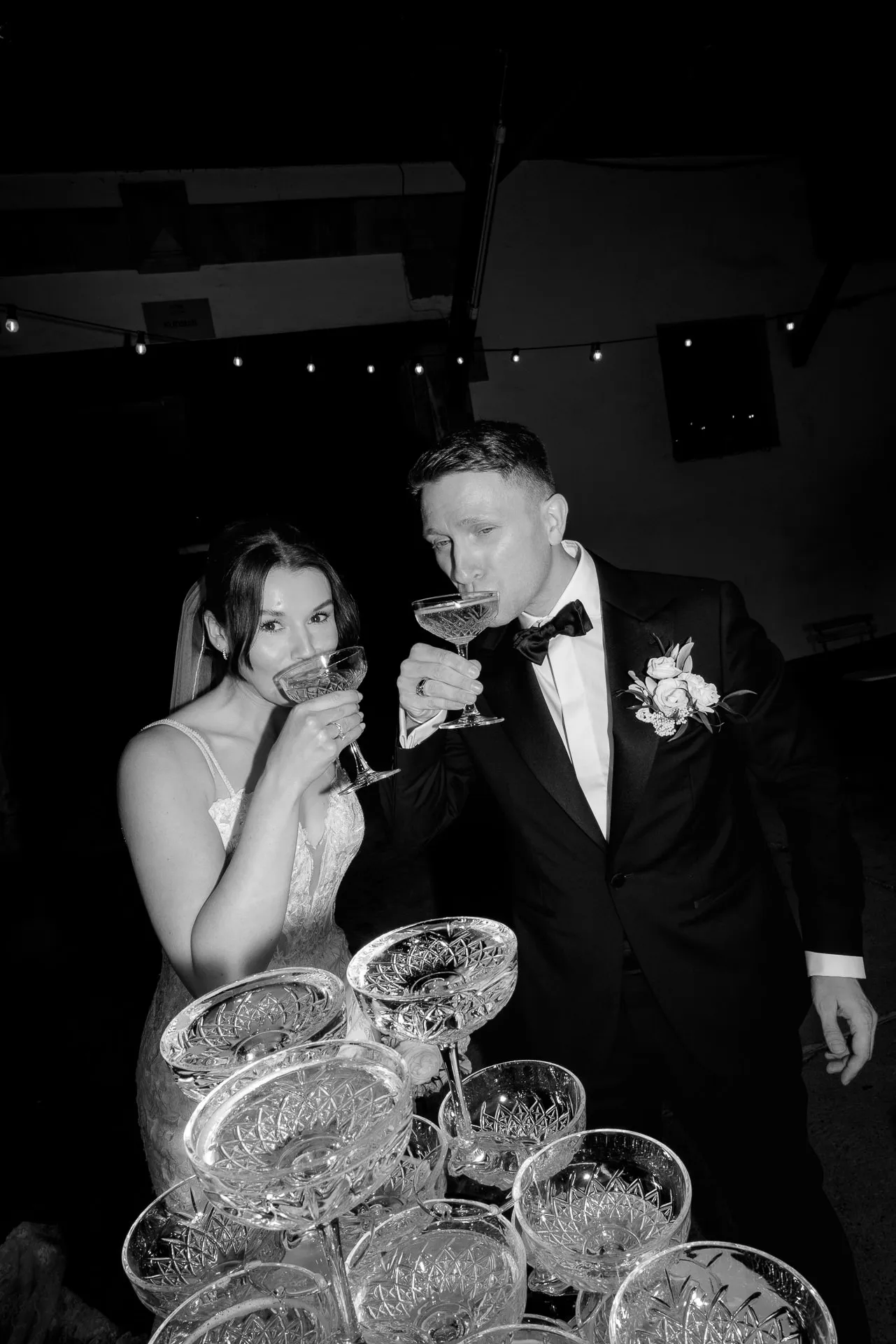 Toasting with champagne before champagne tower at wedding in black and white