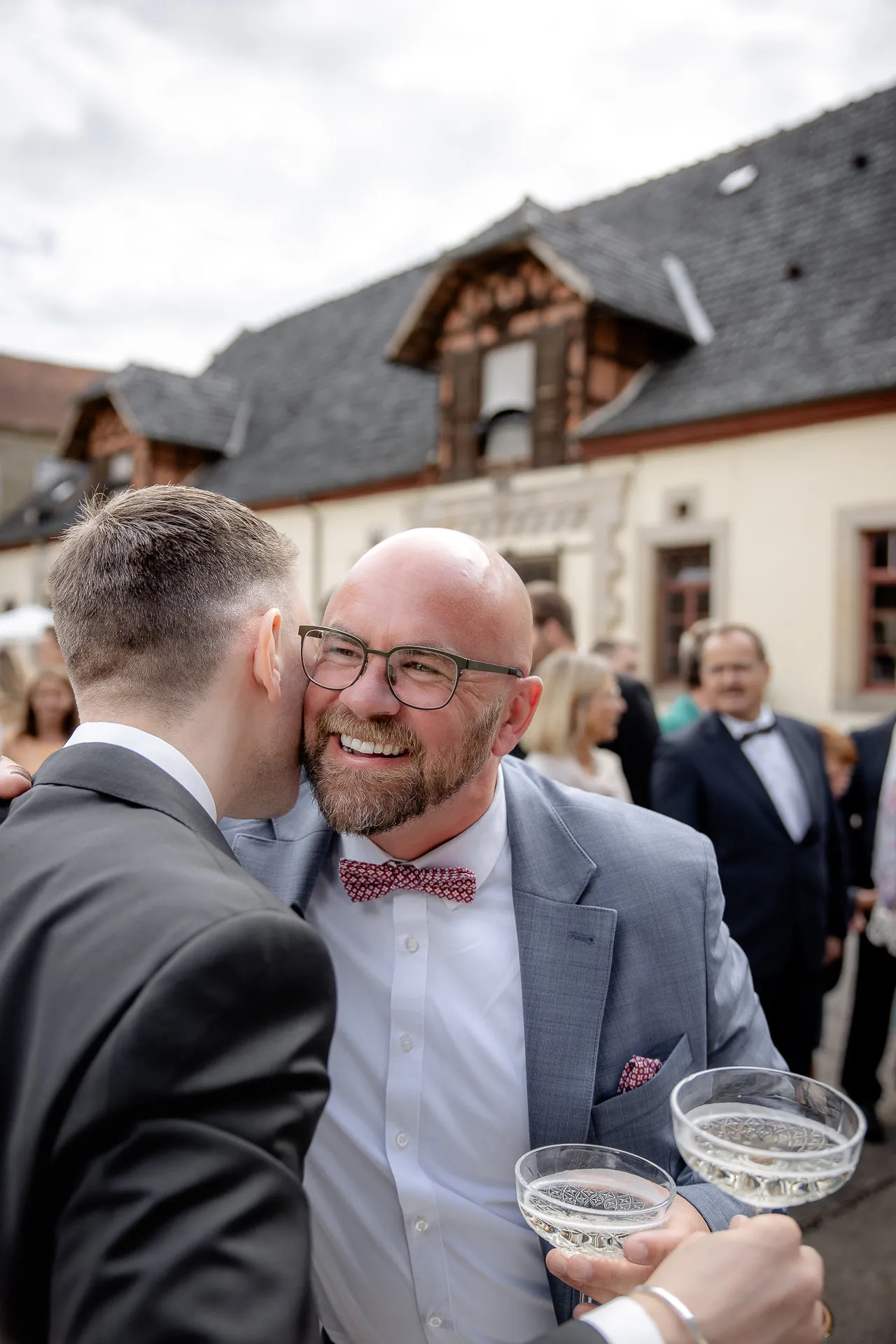 Joyful wedding guests with champagne during congratulations at Schloss Eyrichshof