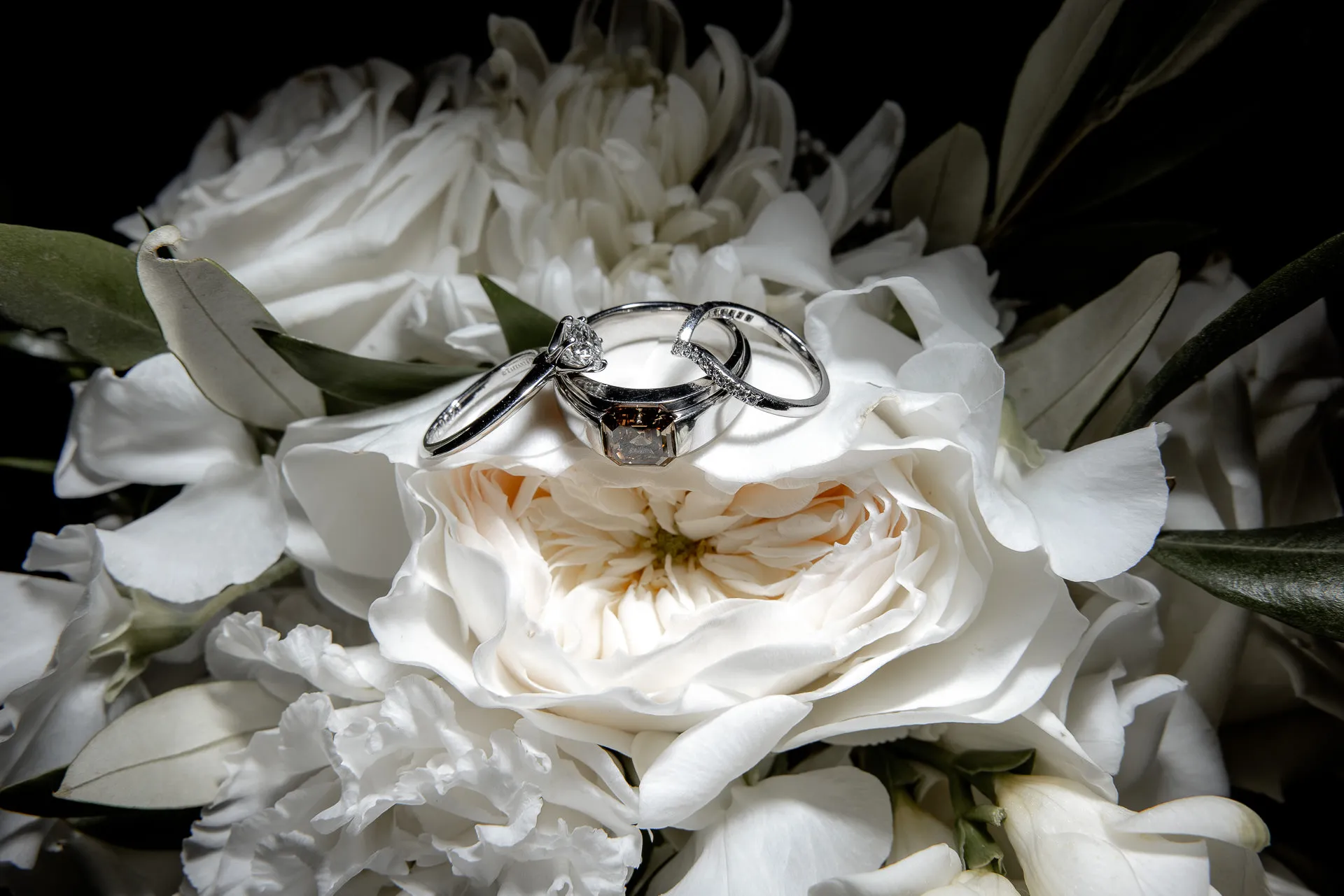 Wedding rings on white bridal bouquet detail shot at wedding Schloss Eyrichshof