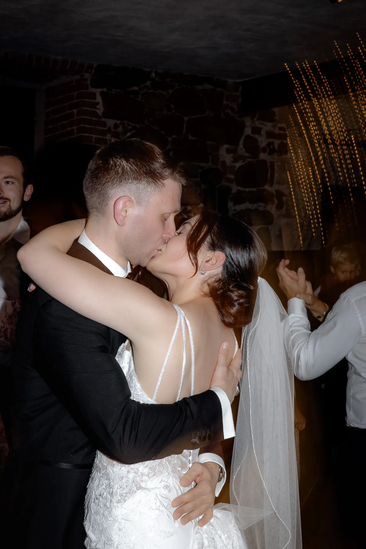 Romantic kiss between bride and groom at wedding party in historic vault Schloss Eyrichshof