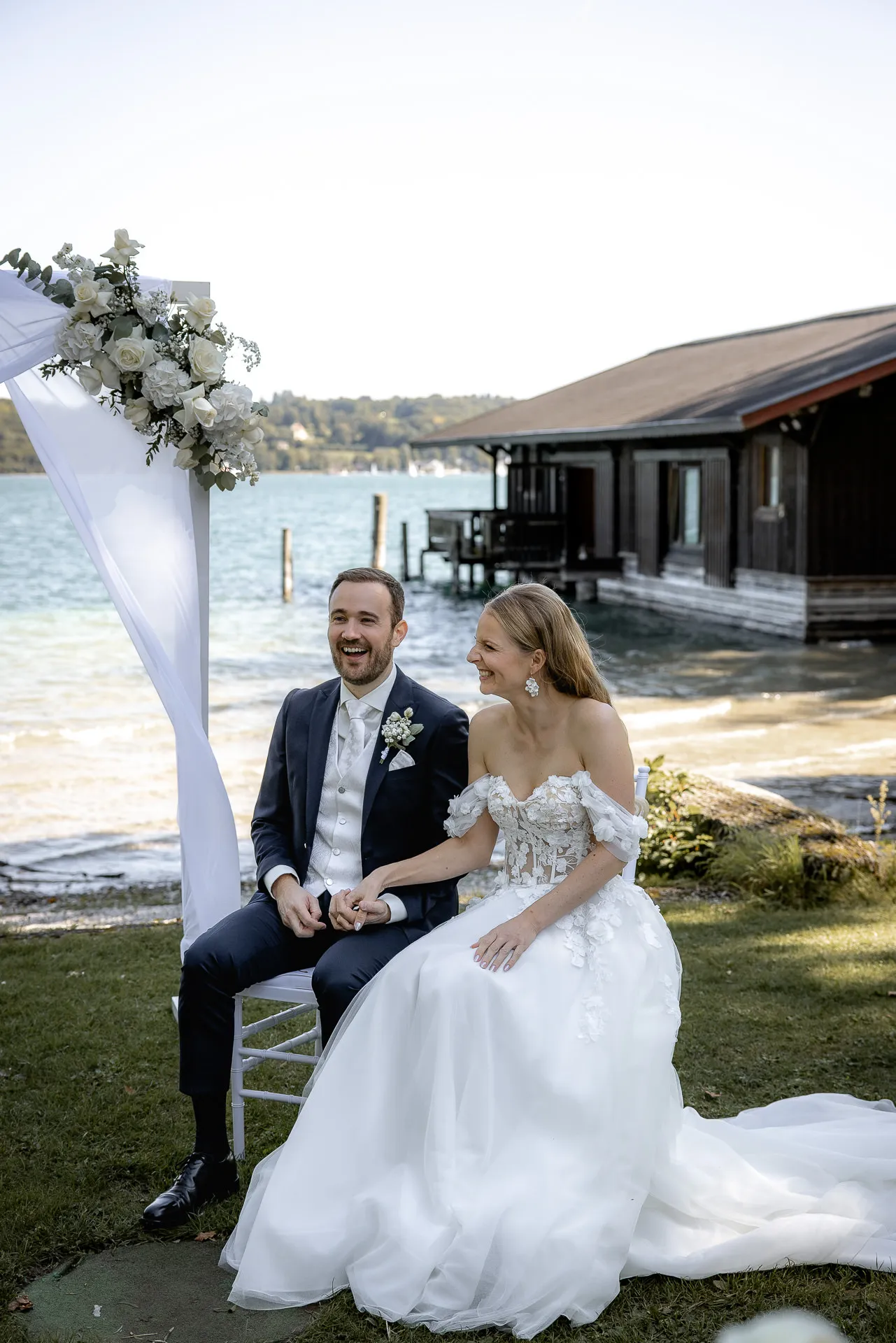 Couple sitting together after ceremony at wedding arch