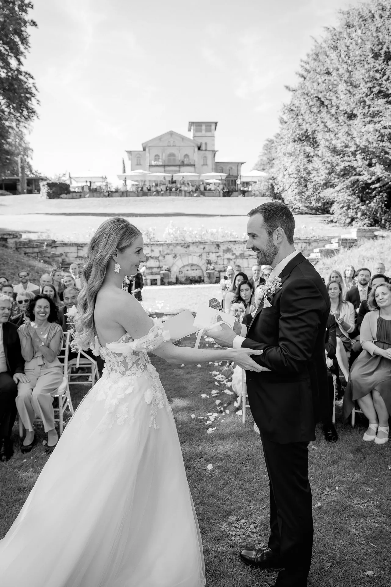 Couple exchanging vows at ceremony with La Villa in background