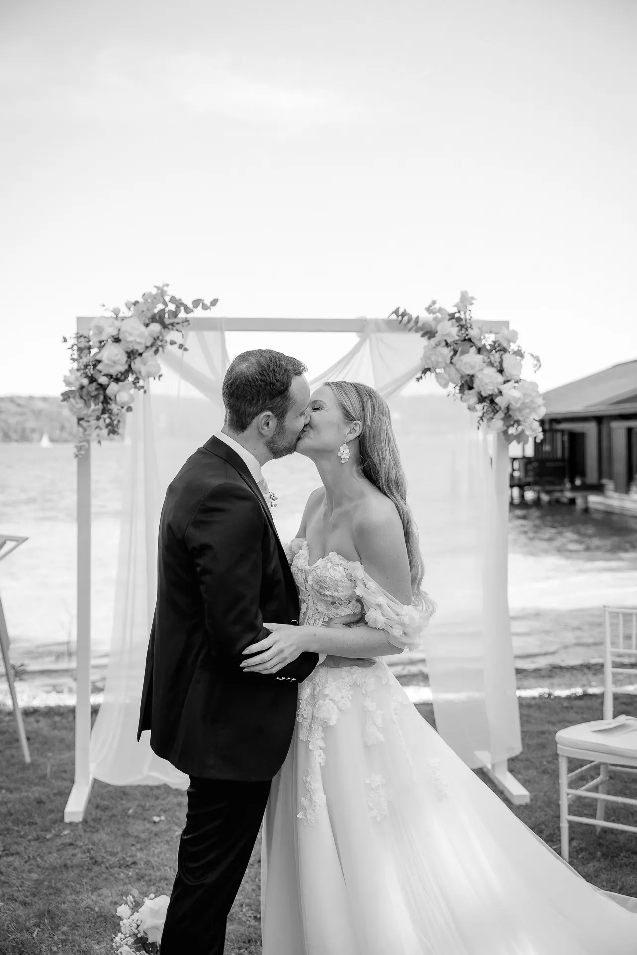 Intimate couple kissing at wedding arch black and white La Villa