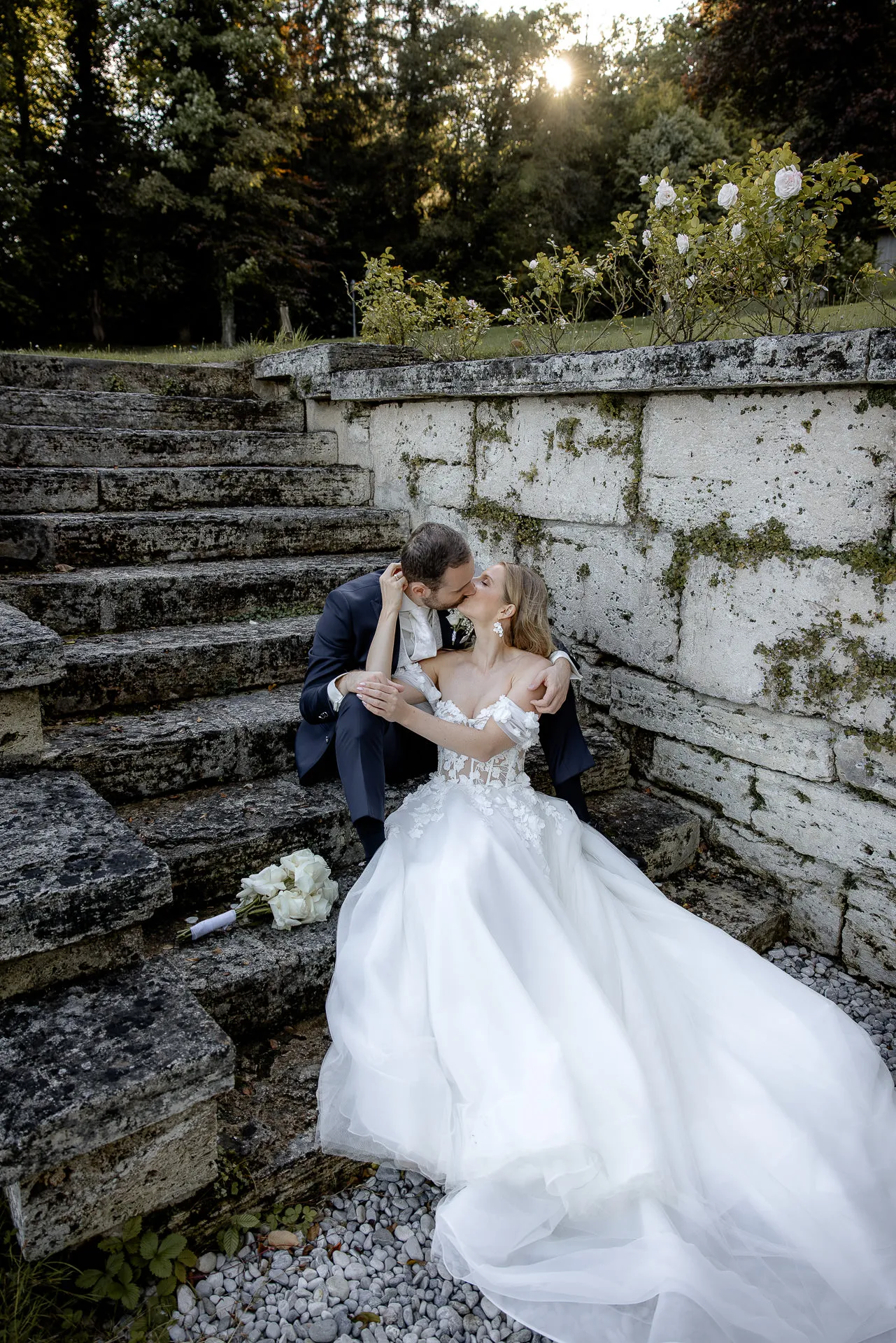 Couple sitting and kissing on historic stone steps La Villa