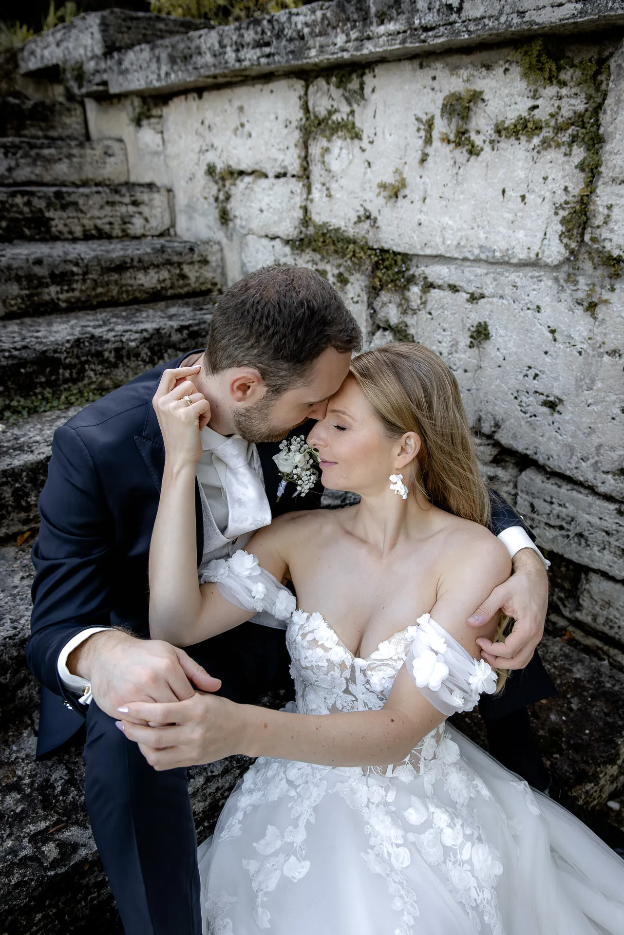 Couple sitting intimately on stone steps in golden light