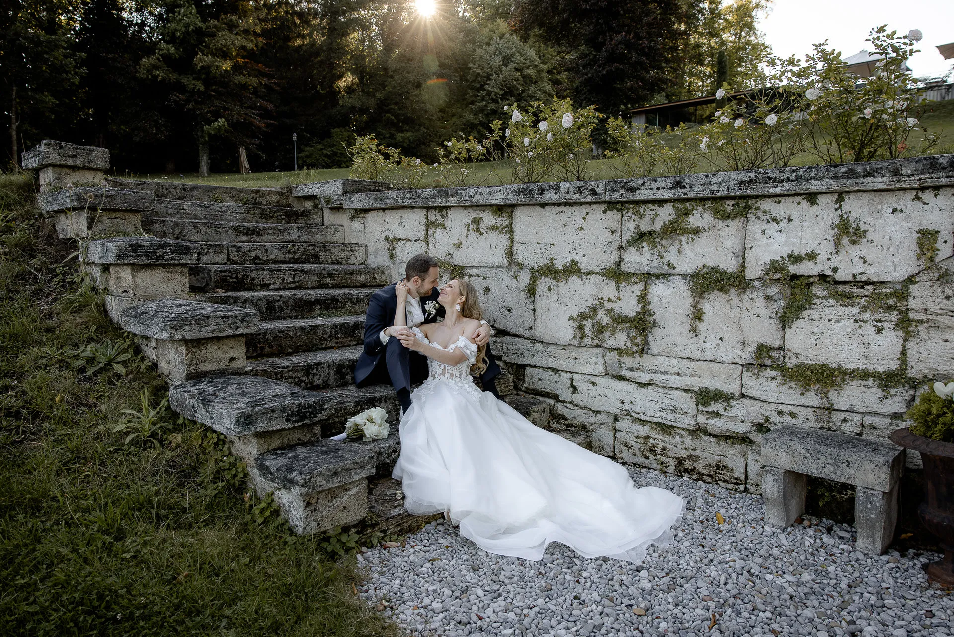 Couple sitting romantically on historic stone steps at sunset