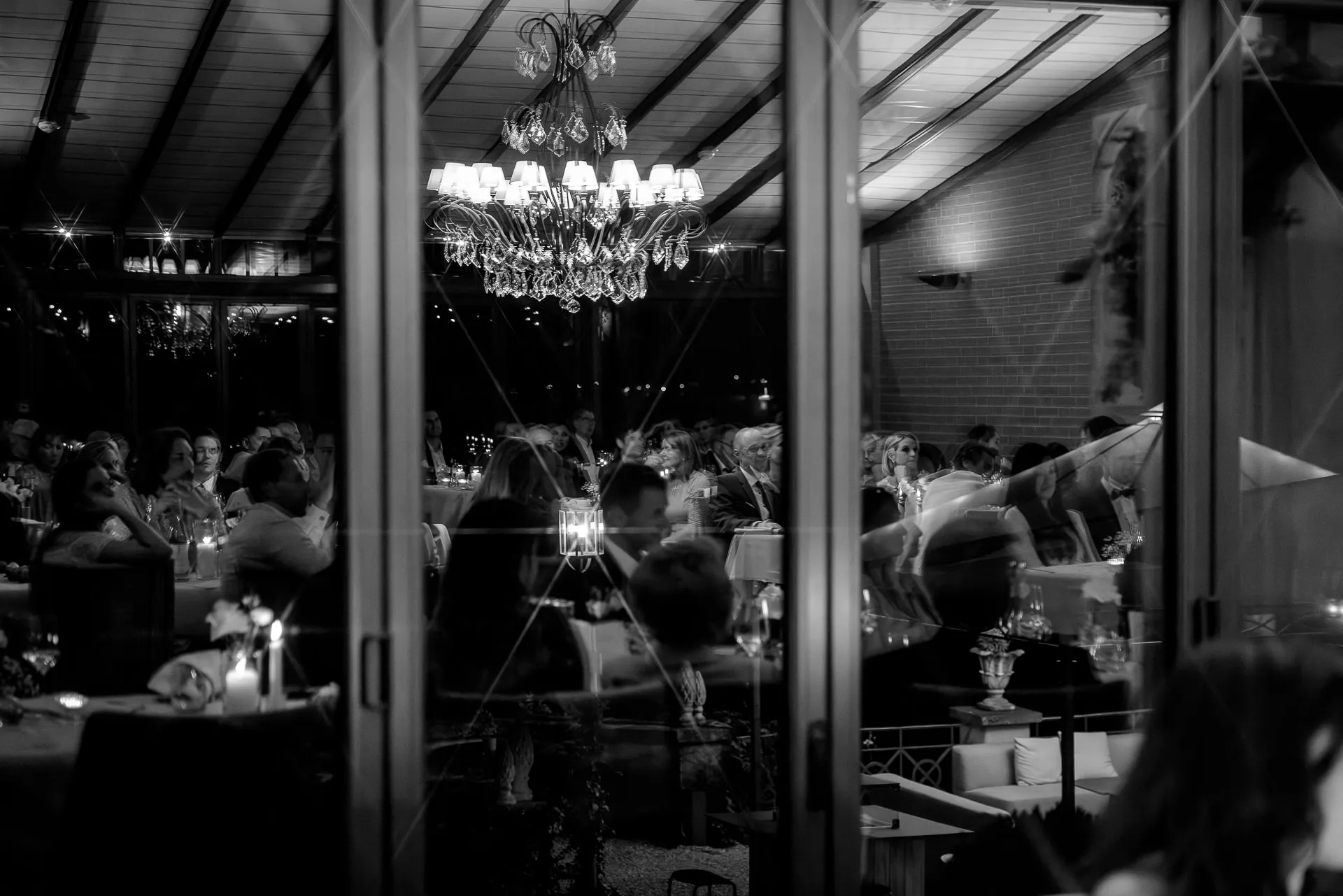 Evening reception with chandelier and guests black and white La Villa