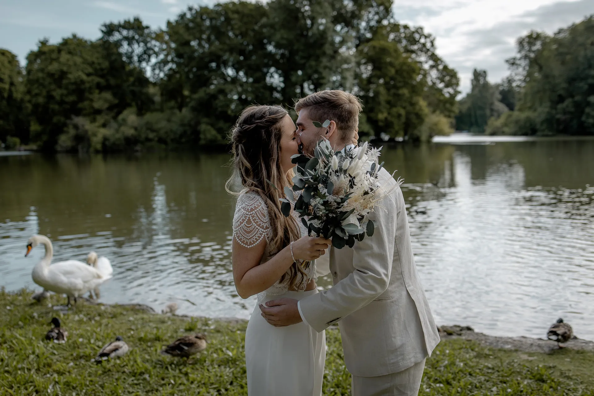 Romantic kiss during First Look in Englischer Garten Munich with swans