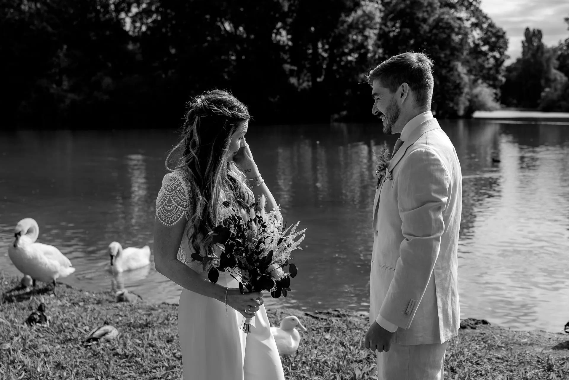 Authentic moment during First Look – bride and groom by the lake in Englischer Garten Munich