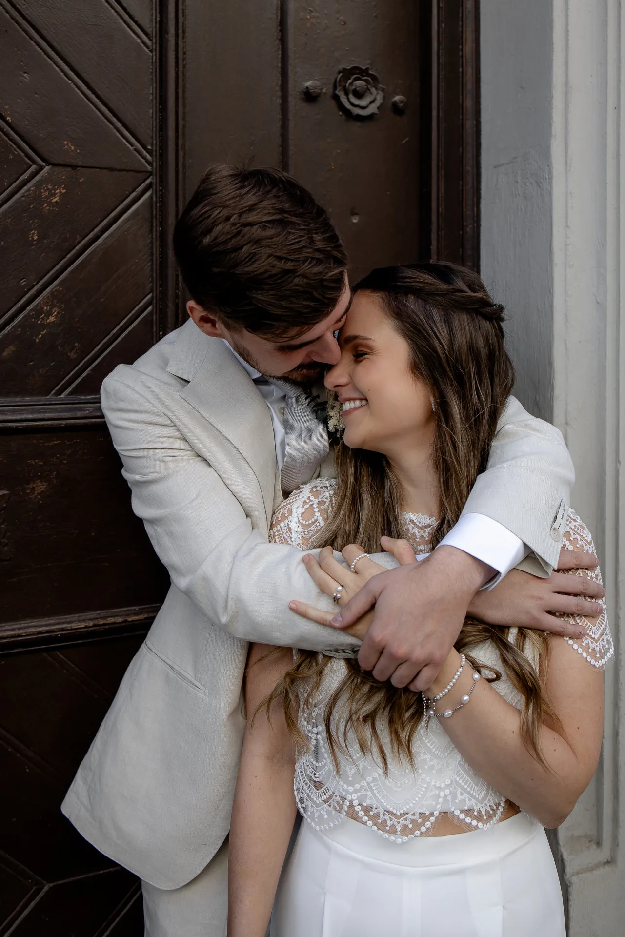 Intimate couple portrait in front of old wooden door – authentic wedding photography Munich