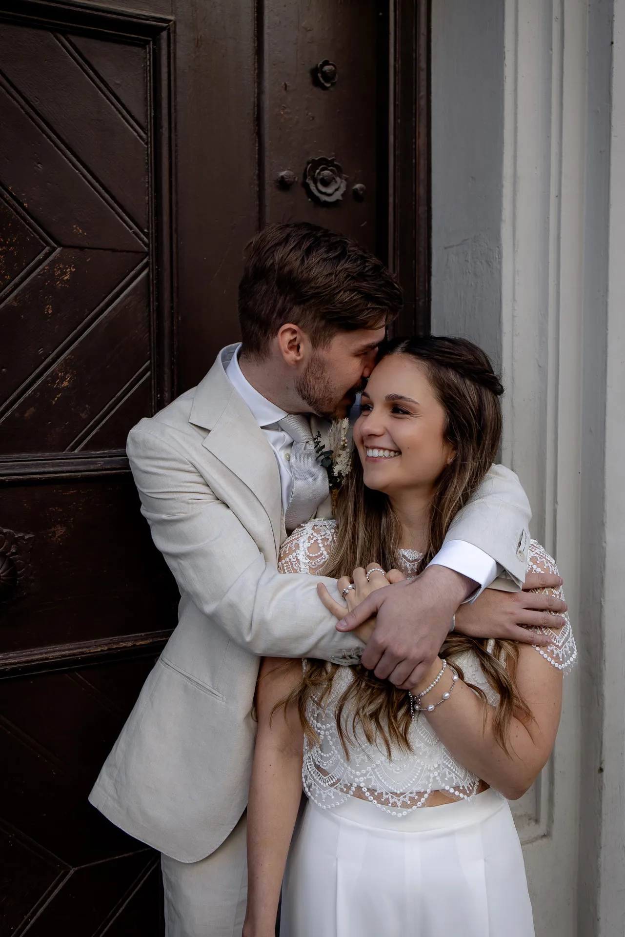 Tender couple portrait in front of historic door in Munich