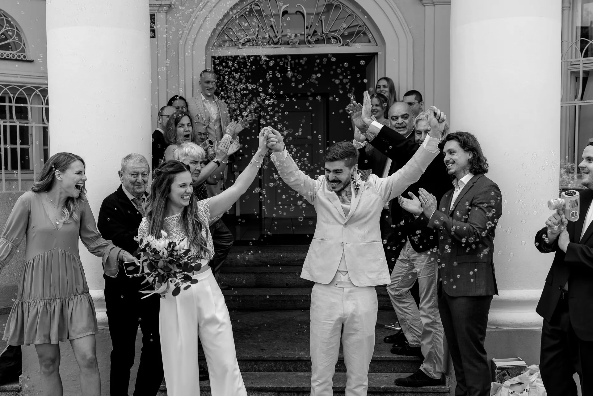 Cheering bride and groom with bubbles after civil ceremony Munich