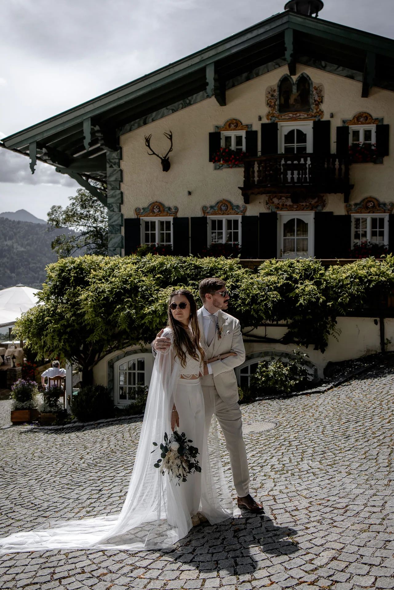 Bride and groom in front of traditional Leeberghof at Lake Tegernsee – Bavarian wedding venue