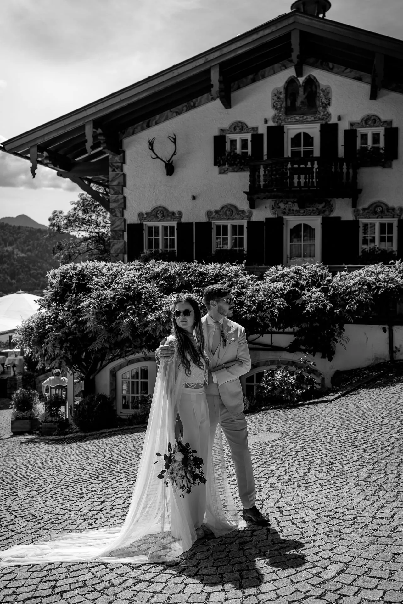 Wedding couple in front of Leeberghof Tegernsee in black and white – traditional Bavarian venue