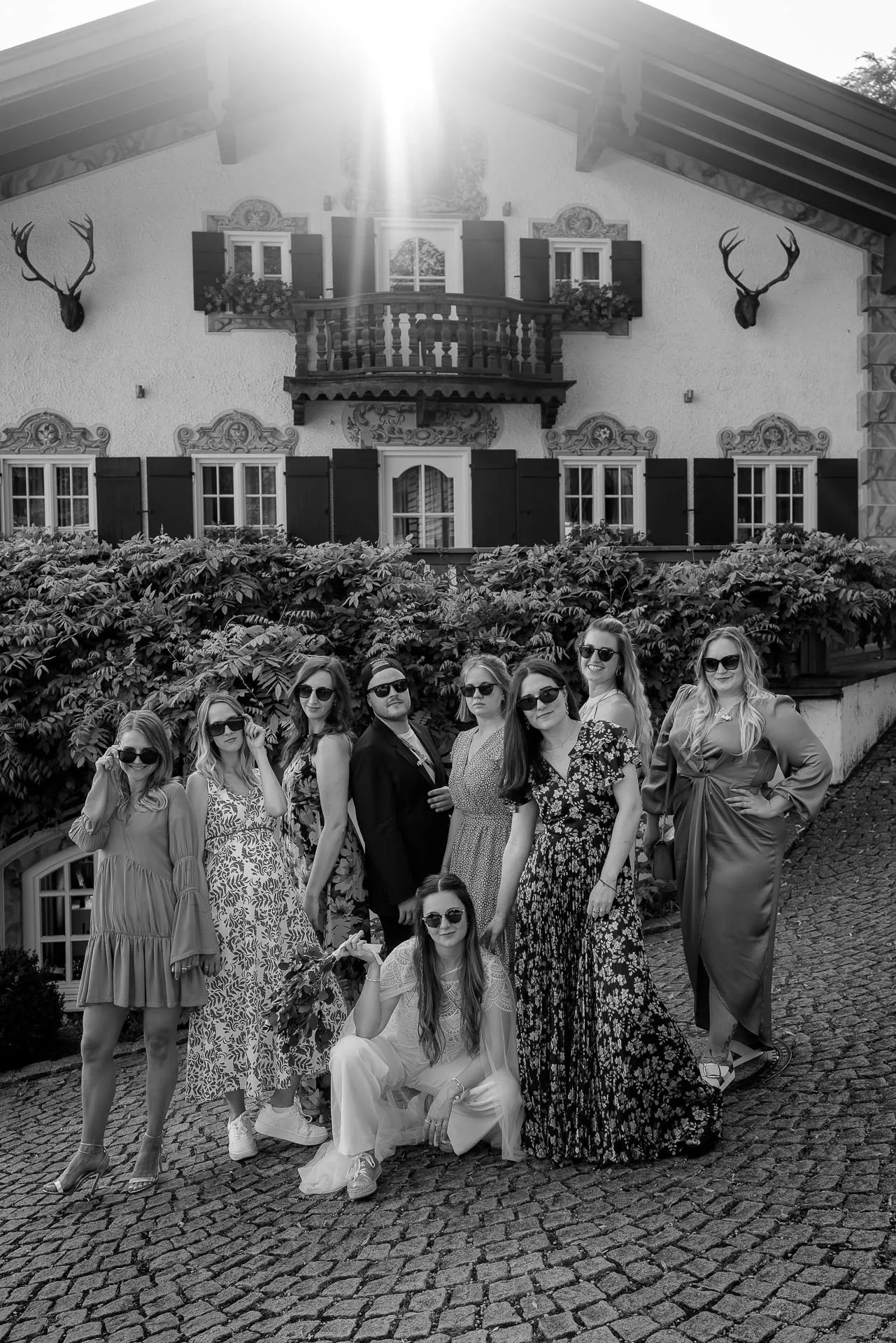 Bride with bridesmaids in front of Leeberghof at Lake Tegernsee – wedding photography in black and white