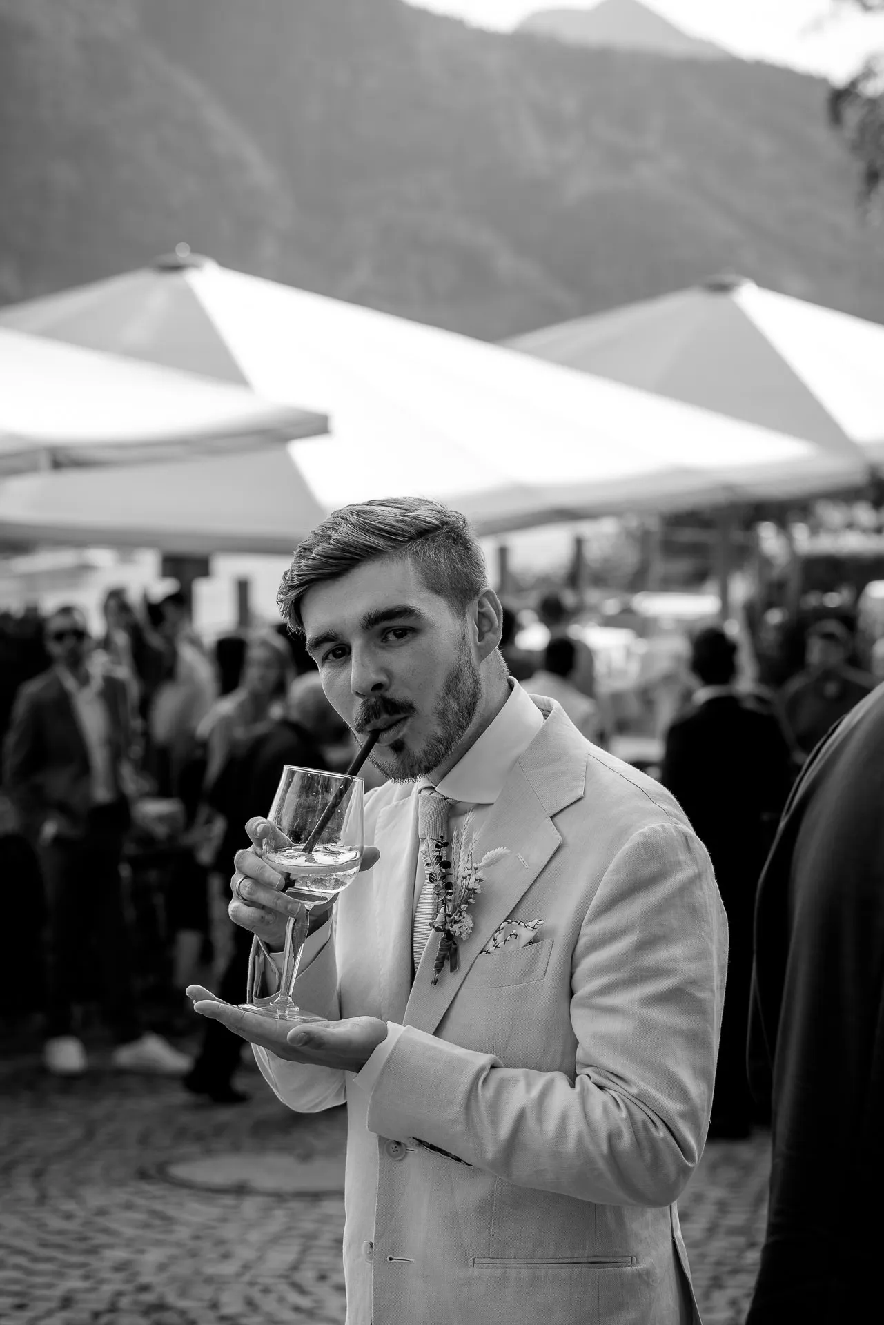 Groom with champagne at Leeberghof celebration in black and white – authentic wedding photography