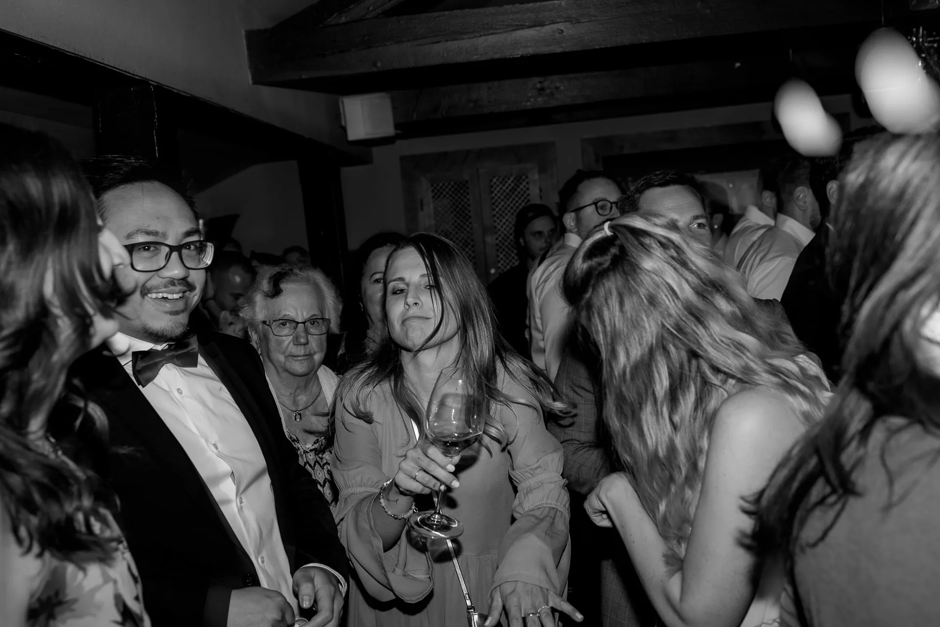 Joyful wedding guests dancing at Leeberghof – authentic party photography in black and white