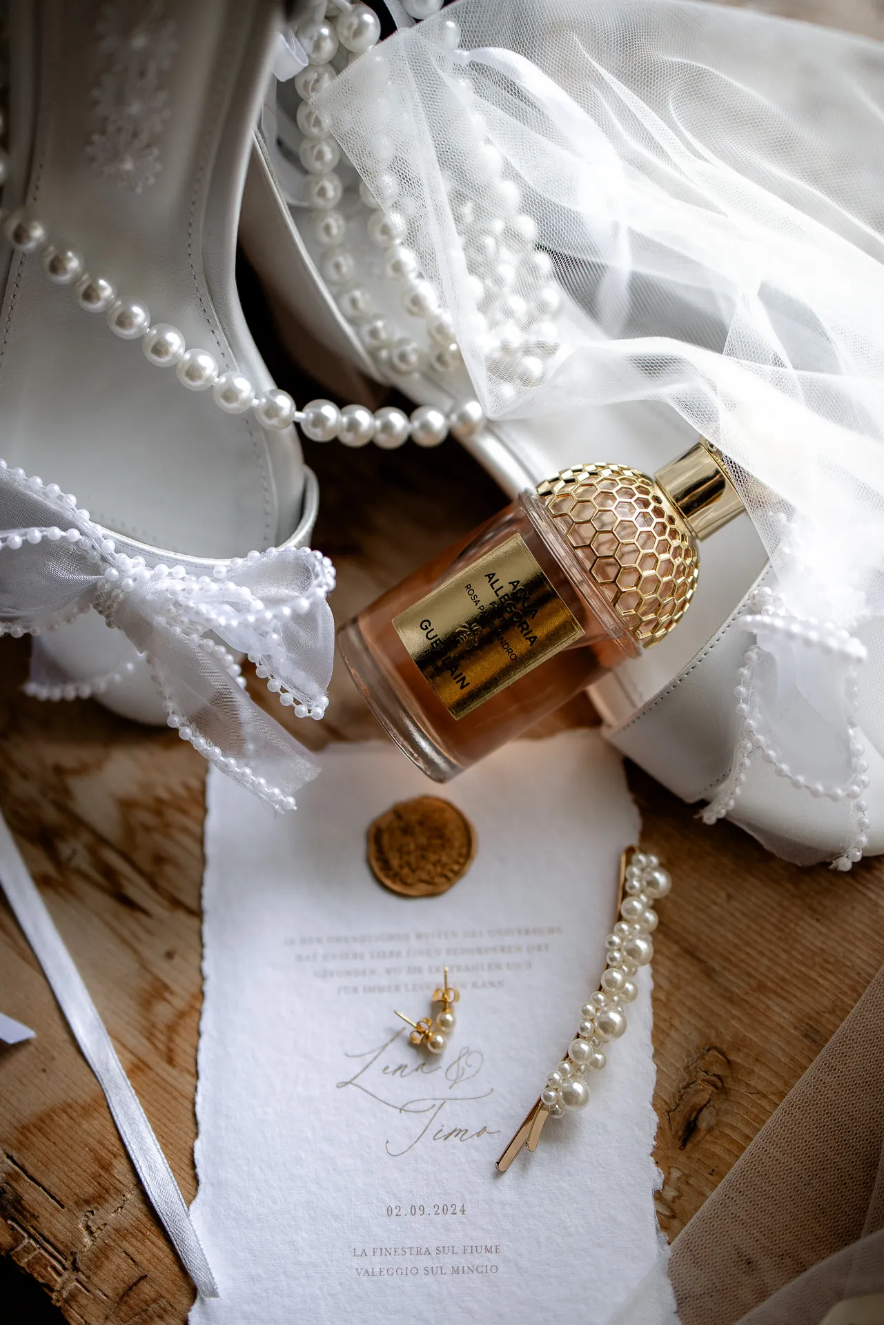 Luxurious wedding details with perfume, pearls and invitation at La Finestra sul Fiume