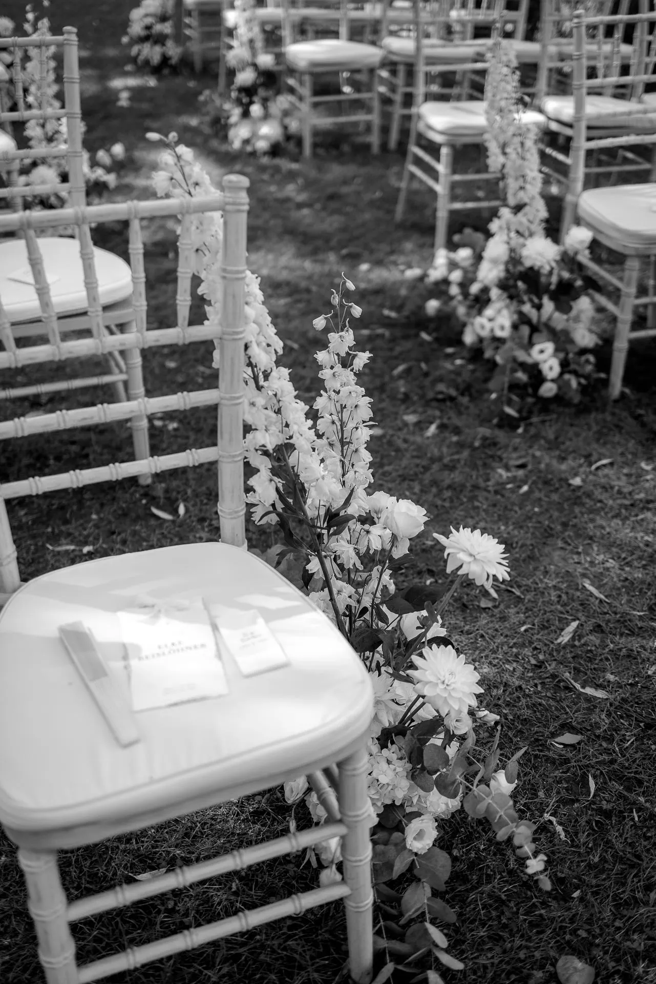 Elegant outdoor wedding ceremony with white chairs and floral decoration